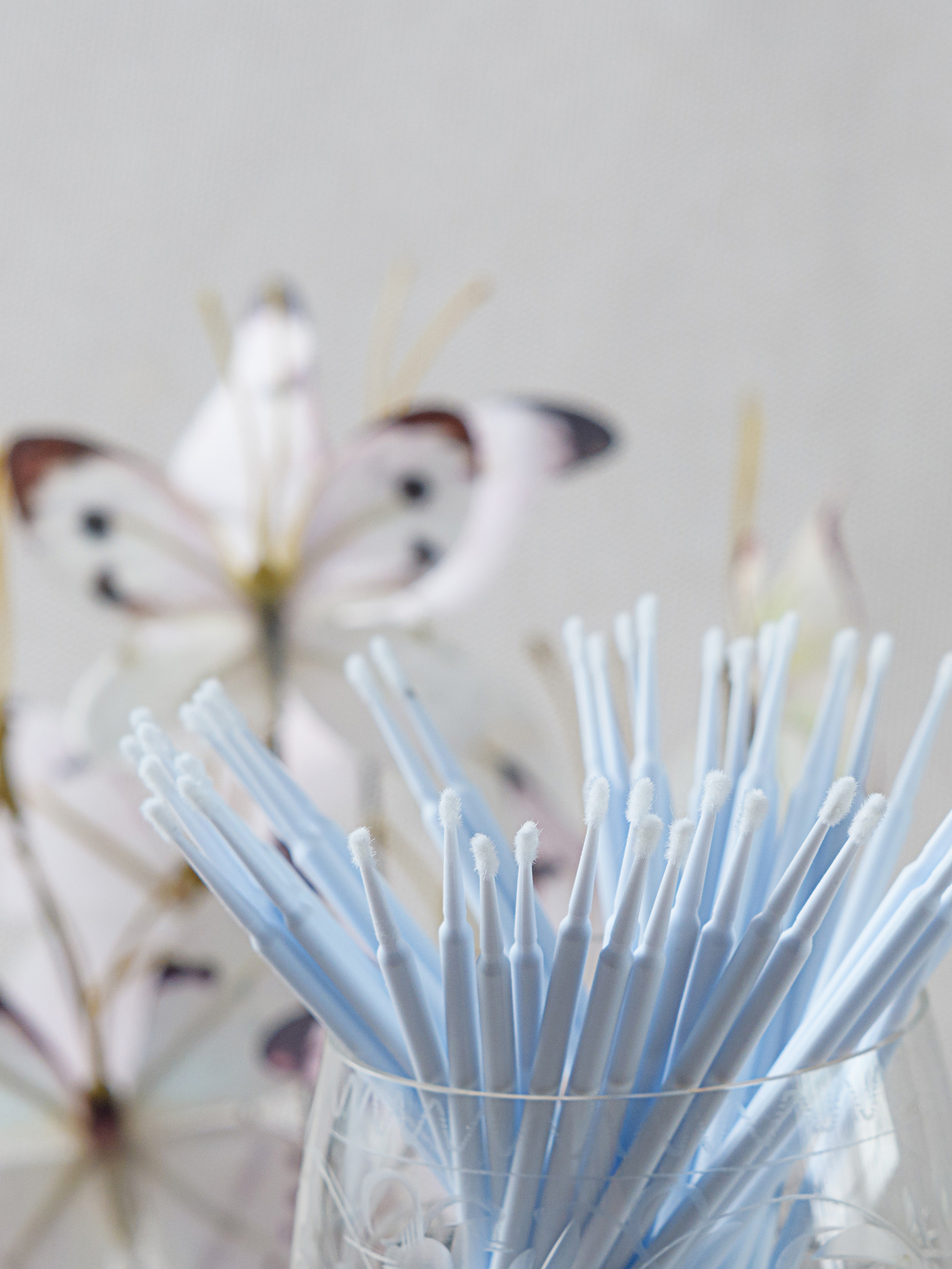 палочки косметические в стакане россыпью на фоне бабочки