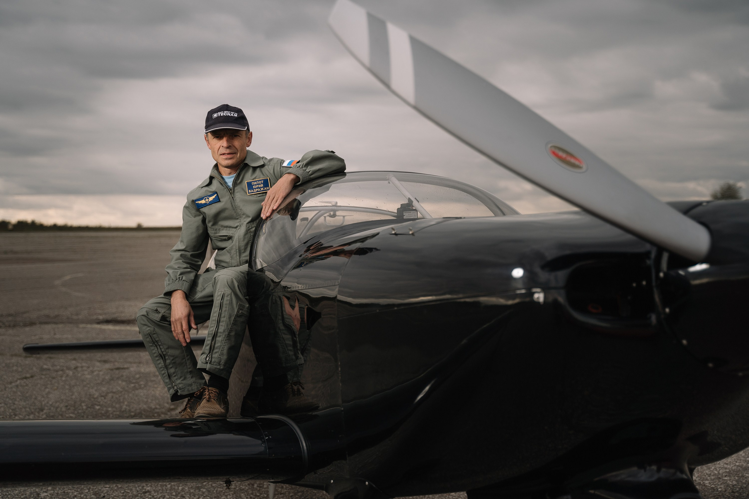 Пилот самолета сидит на крыле