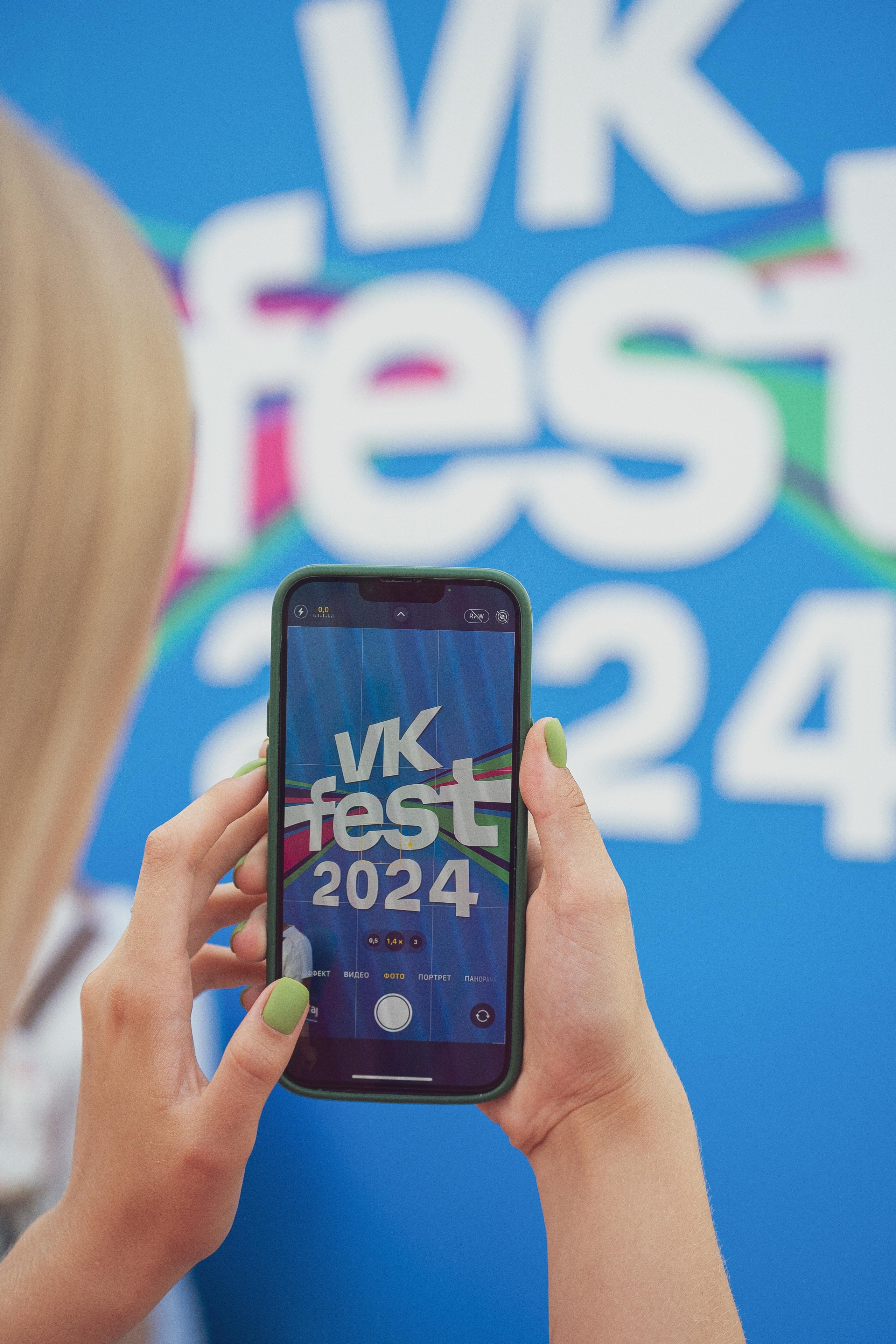 Снимок телефона на фоне надписи с мероприятия 