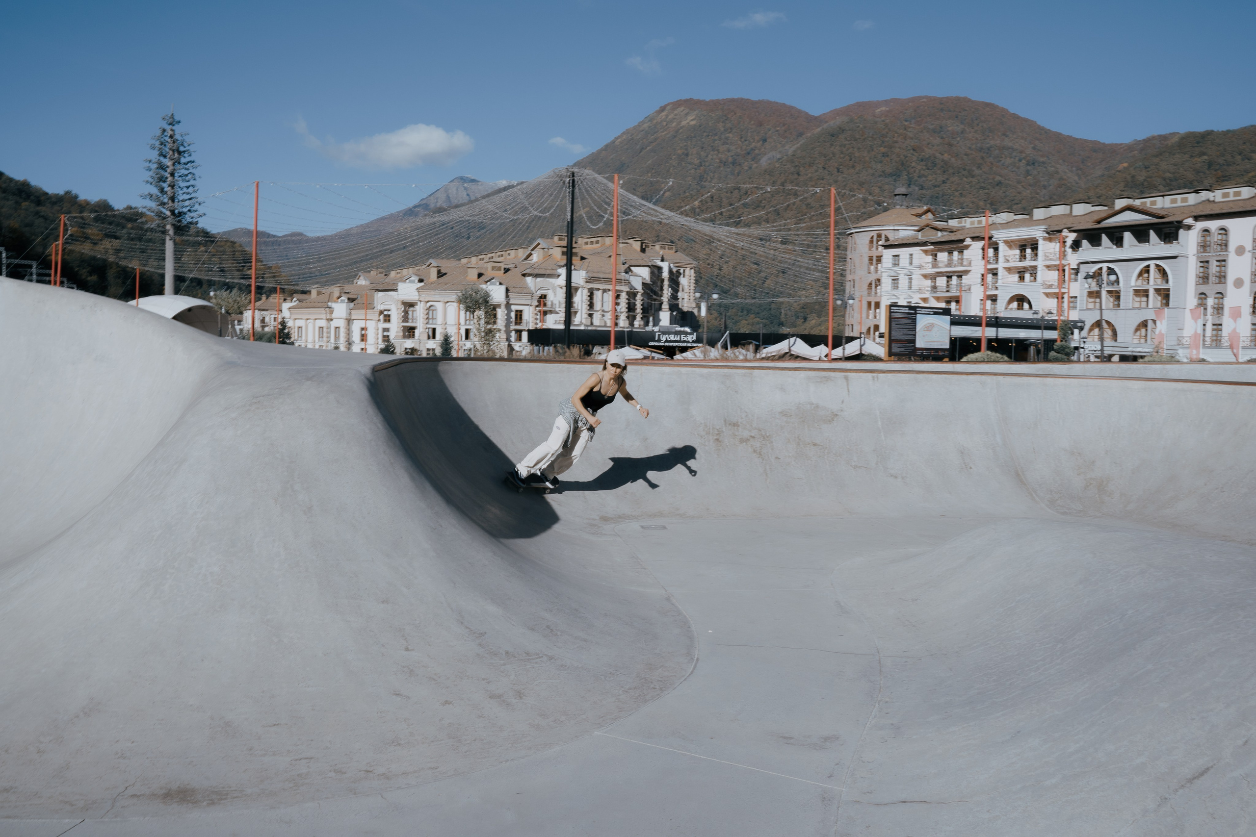 Фотоснимок проезжающей в скейт парке молодой девушки  