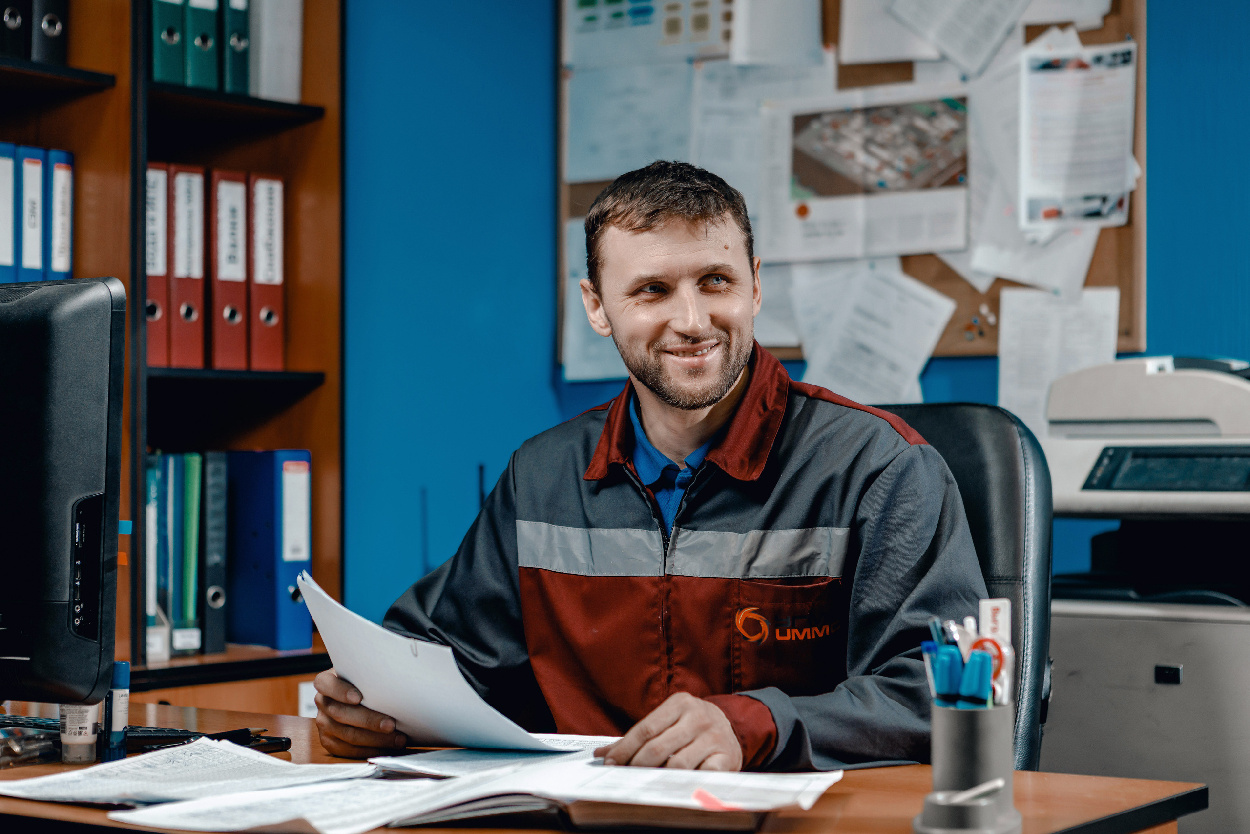 Фотография сотрудника в кабинете за рабочим столом