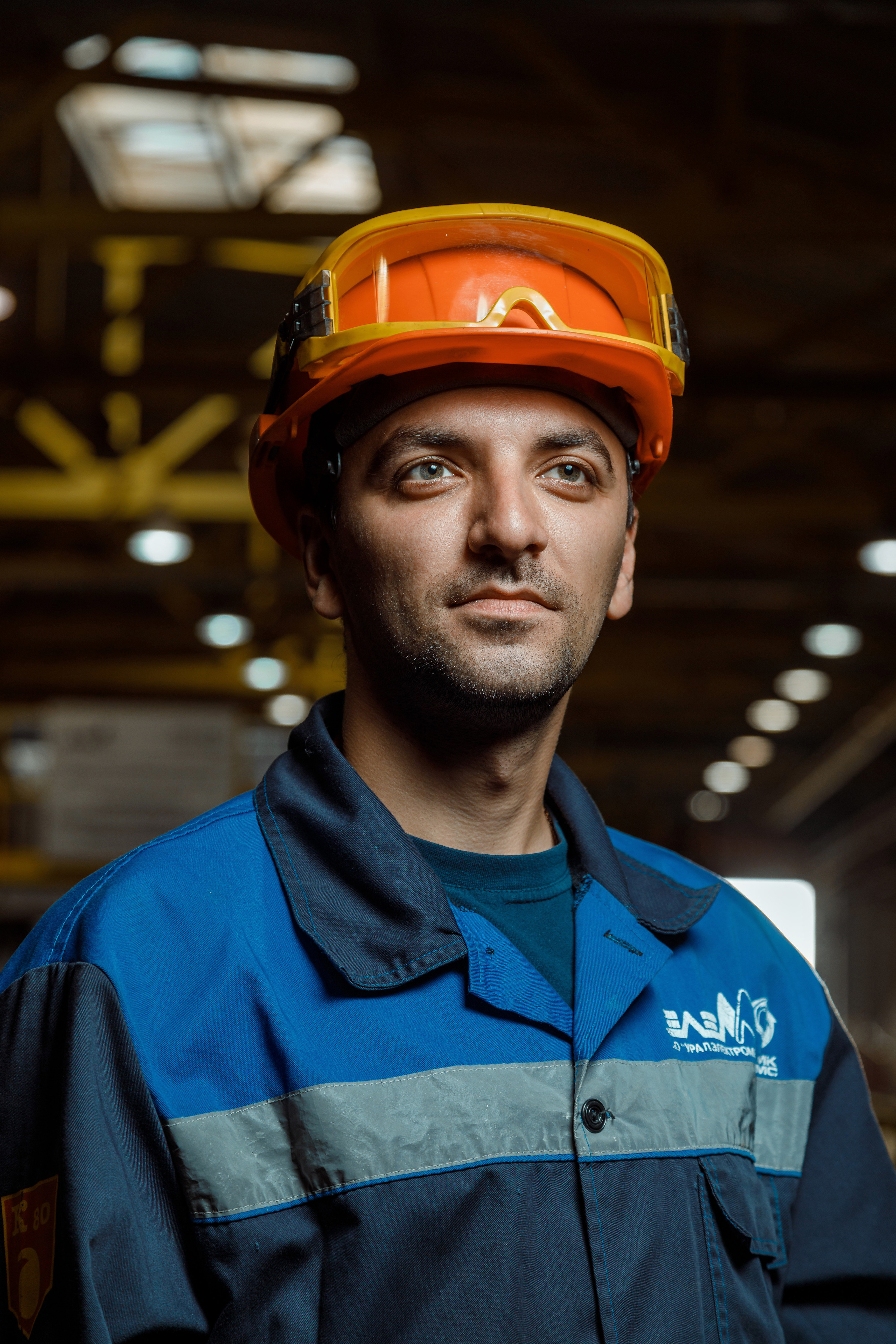 Рабочий в оранжевой каске и защитных очках