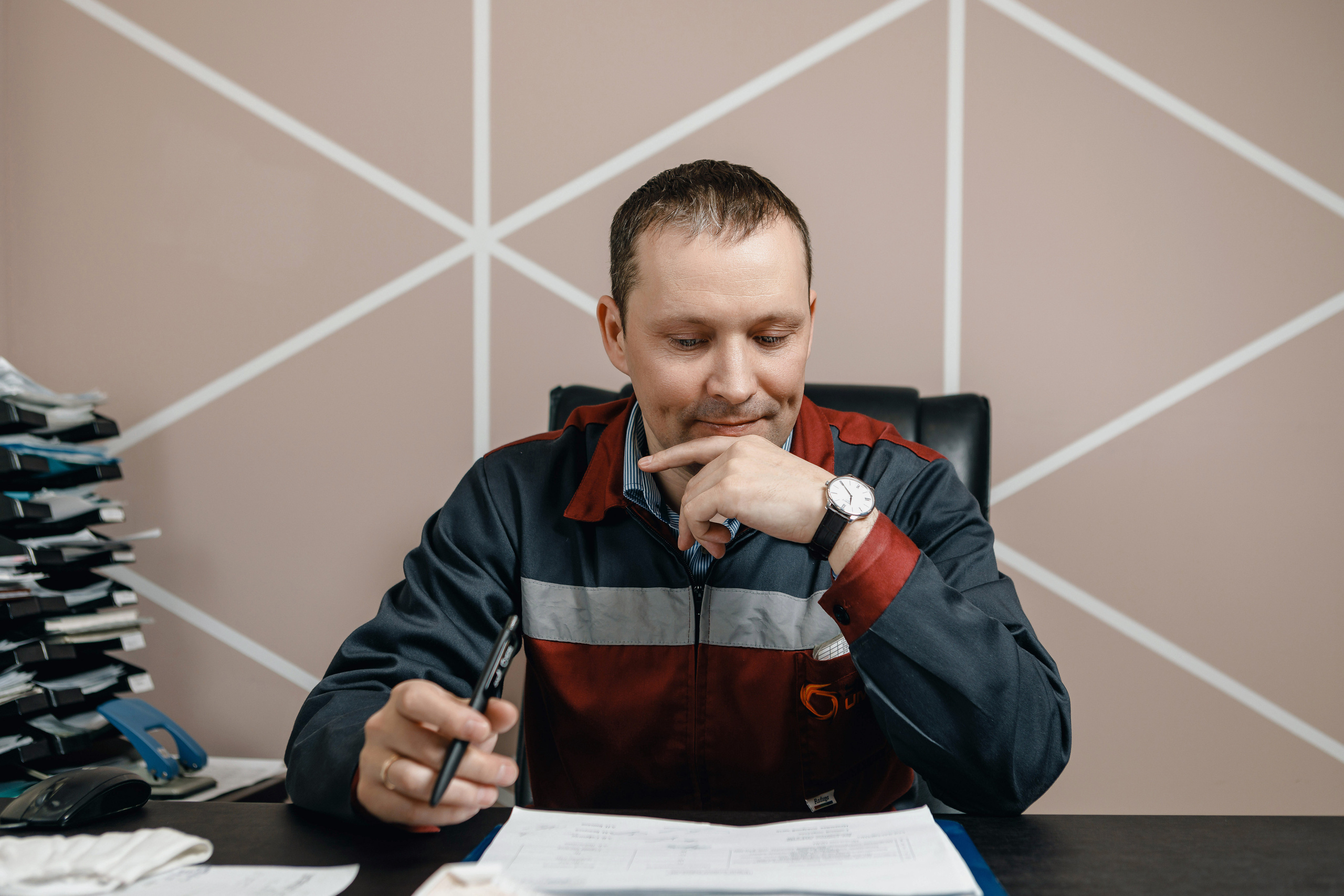 Фотография руководителя цеха за рабочим столом с бумагами