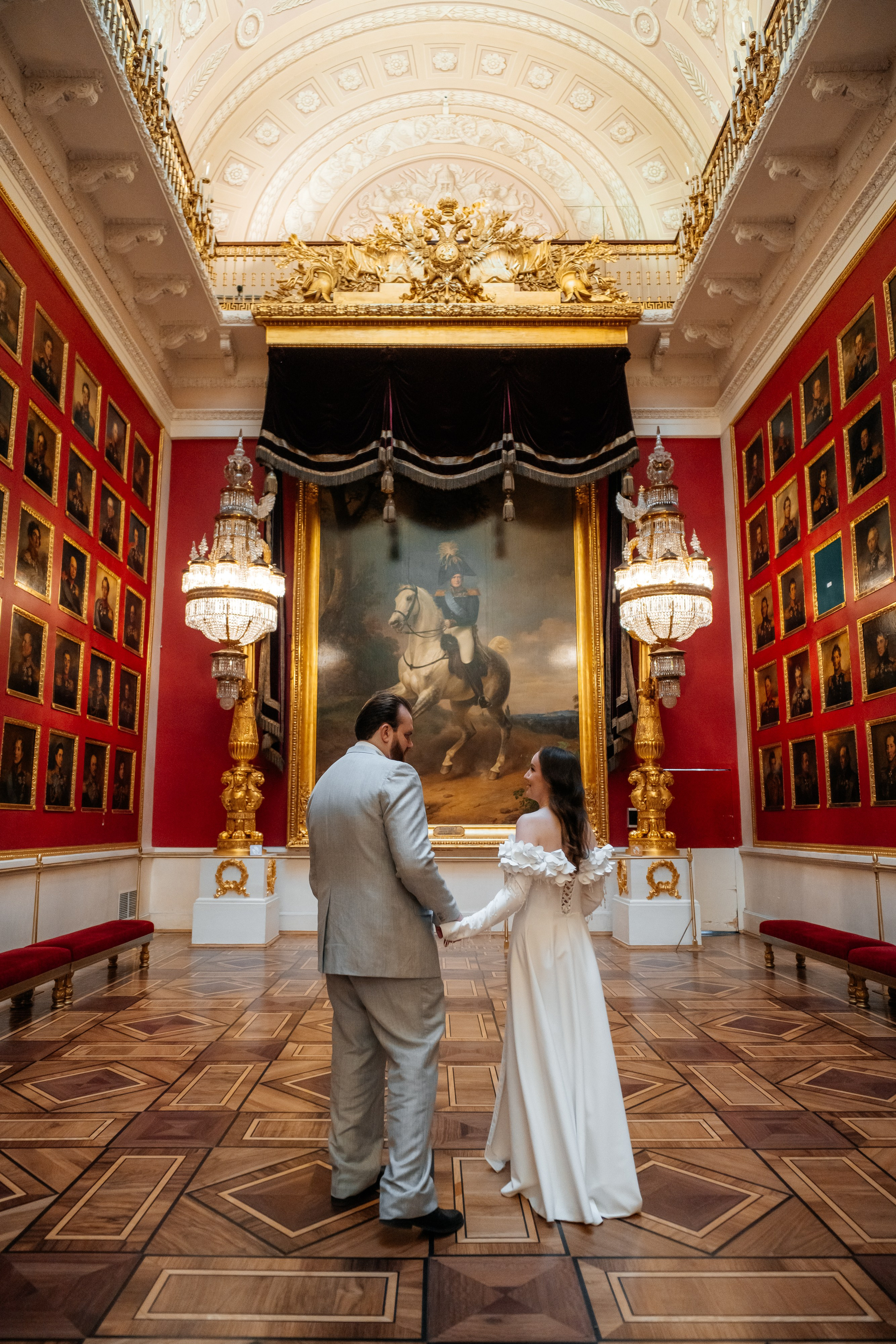 Свадебная фотосессия в Эрмитаже жених и невеста в Военном зале с красными стенами