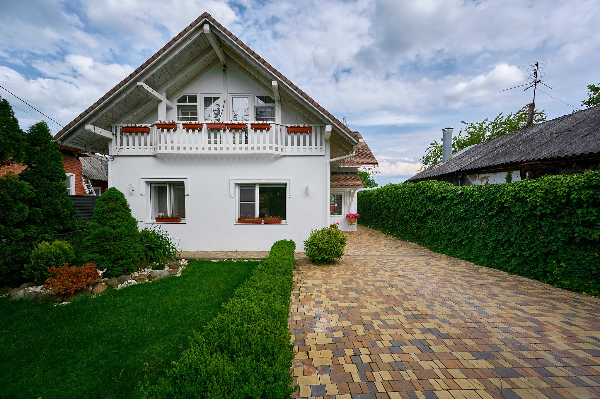 белый двухэтажный дом с аллеей 