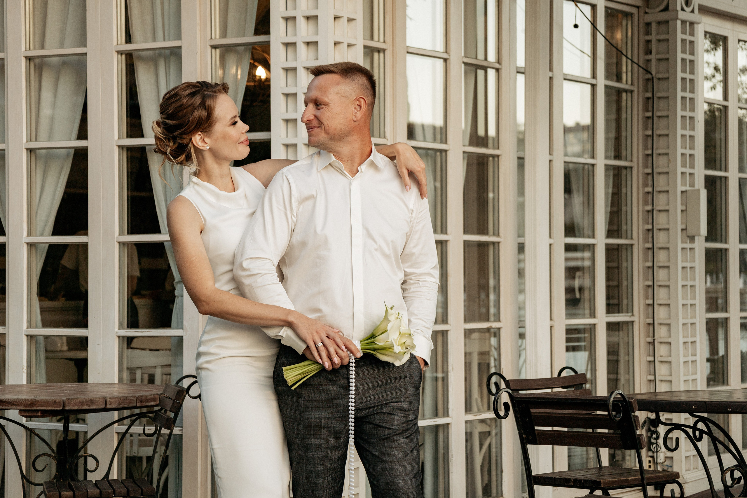 Молодожены танцуют на зеленой лужайке на закате