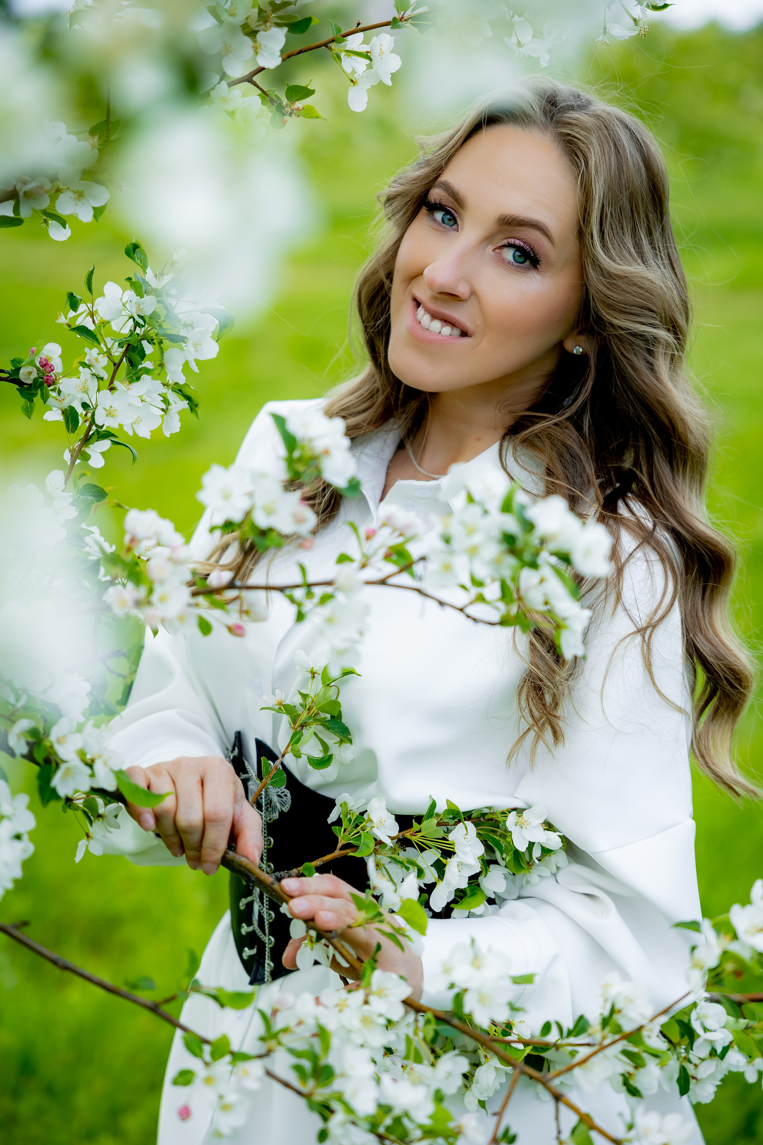 Женщина в белом платье на фоне цветущего поля и облачного неба