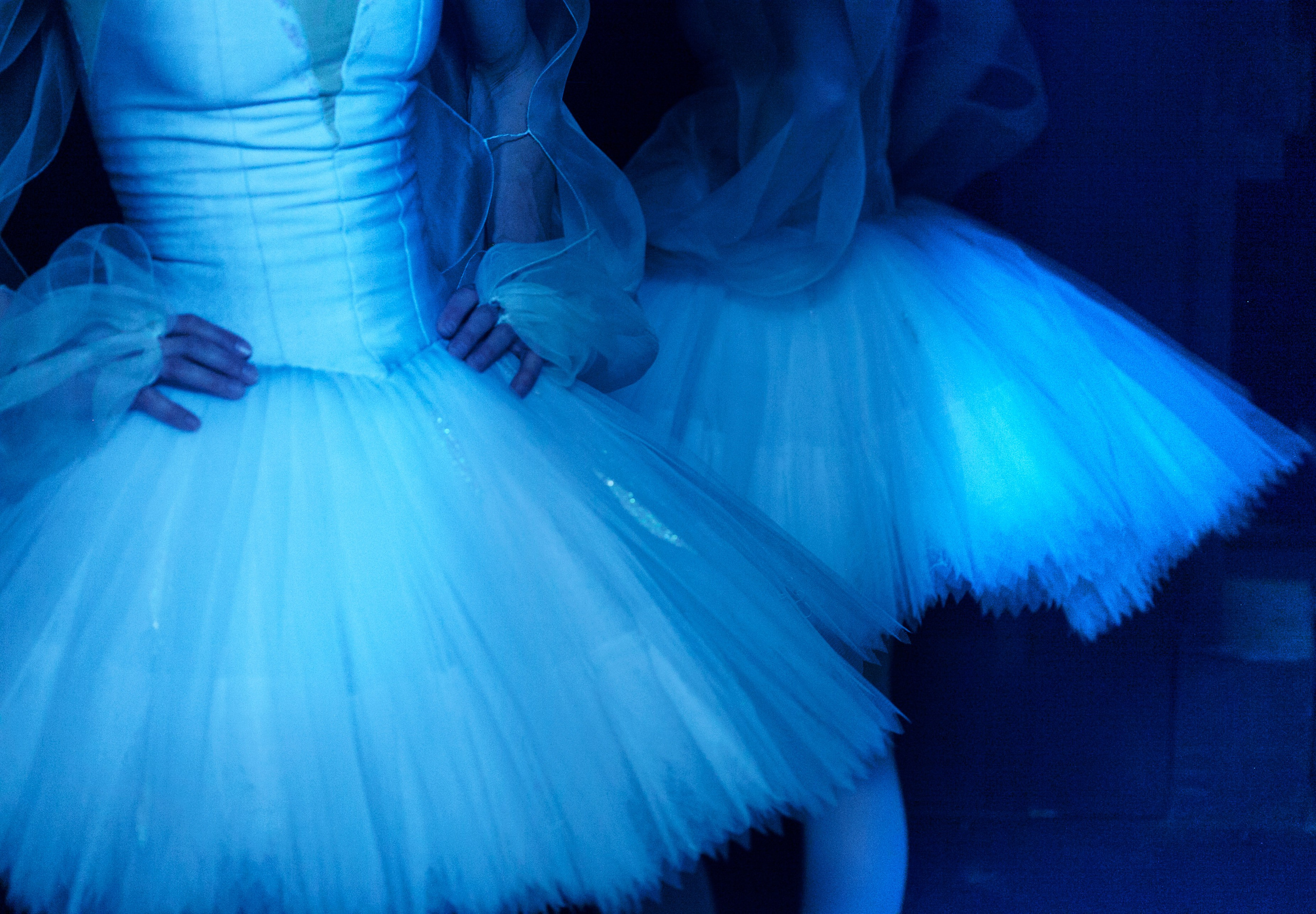 Детали балетного платья и танцовщицы в синем свете, фото балета, студийная балетная фотография