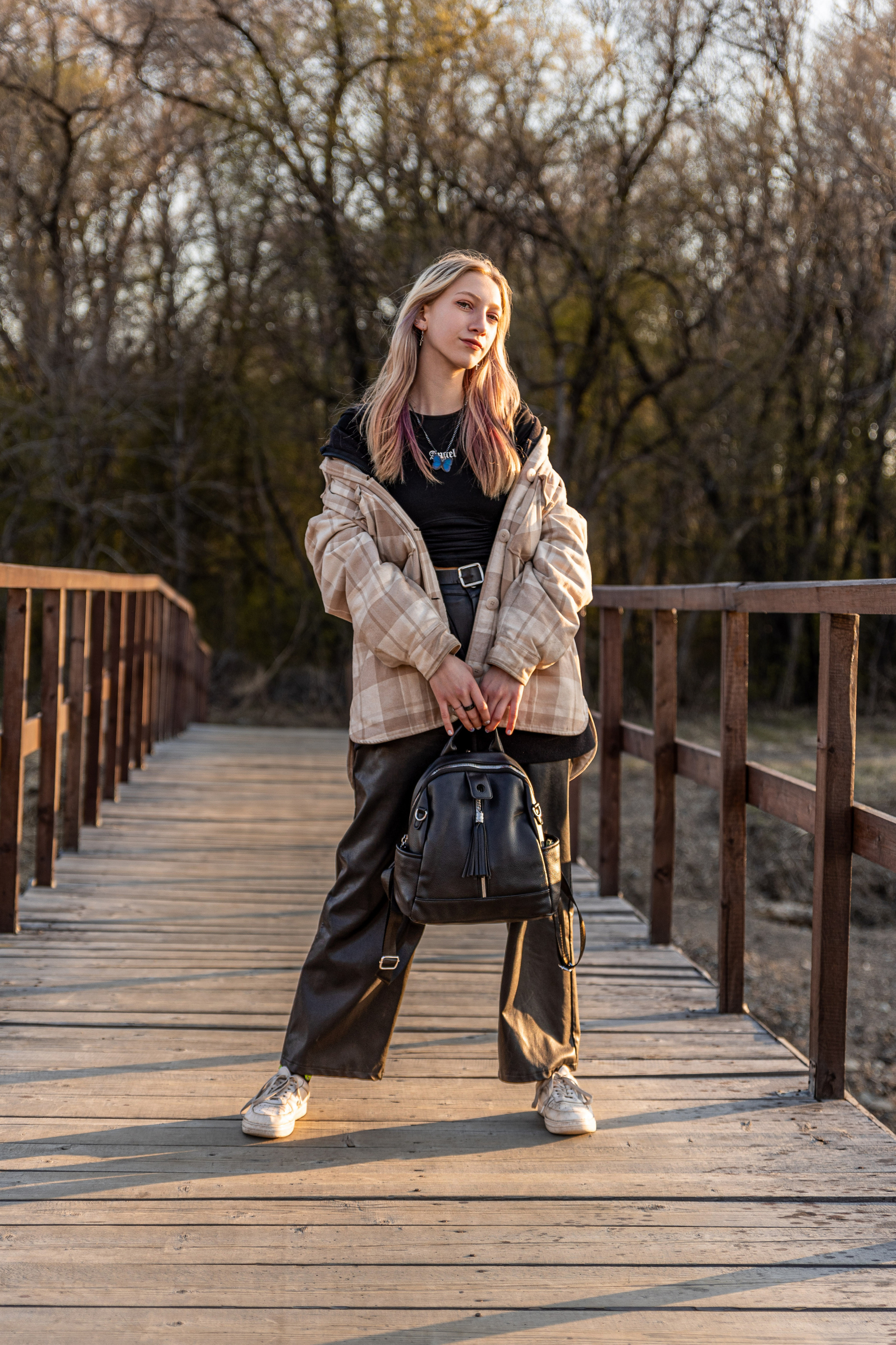 Блондинка на мосту, с сумкой в руках, весна