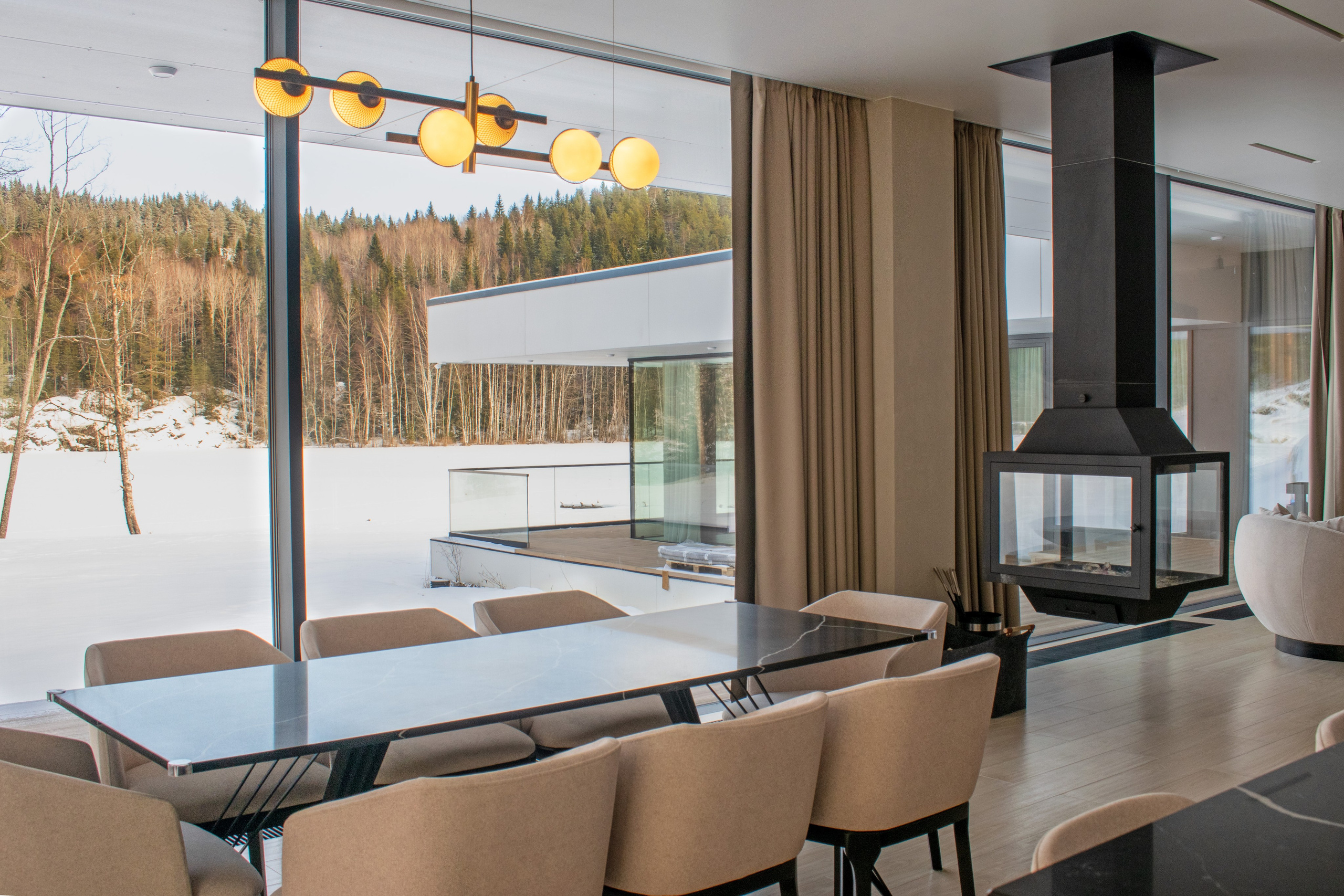 Интерьер недвижимости в Карелии в Сортавальском районе. Гостиная. Фотосъемка обеденного стола с видом на лес.