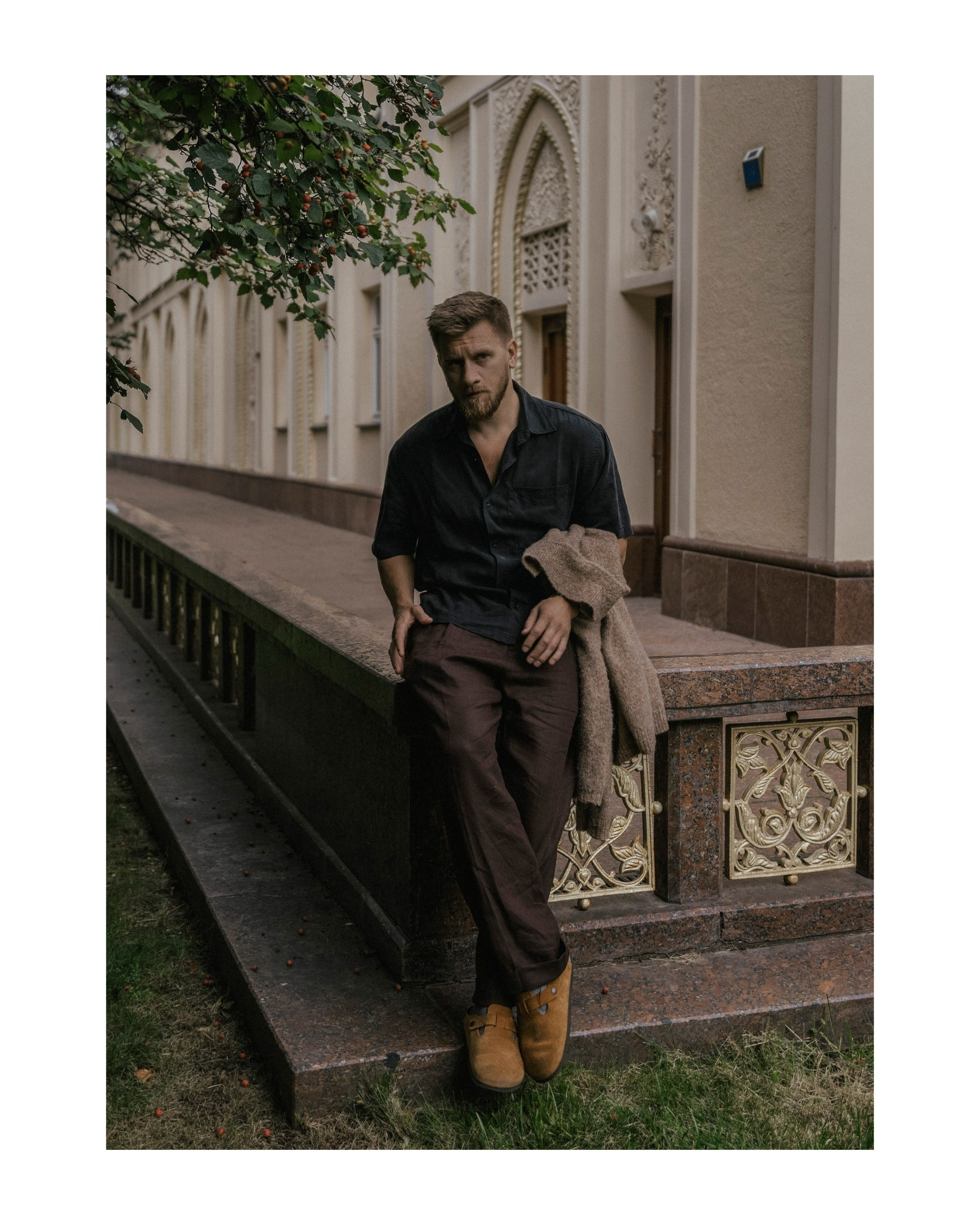 мужчина сидит на заборе