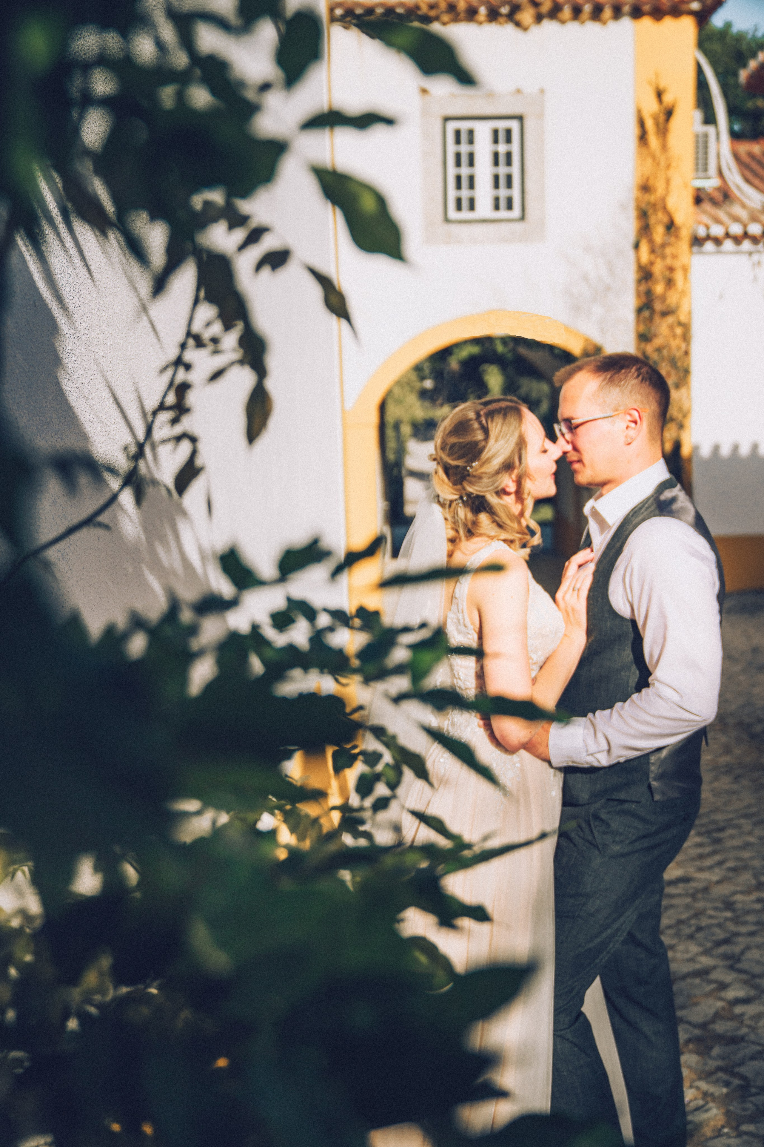 Влюбленная  пара жених и невеста целуется и обнимаются на фоне старинных улочек Португалии