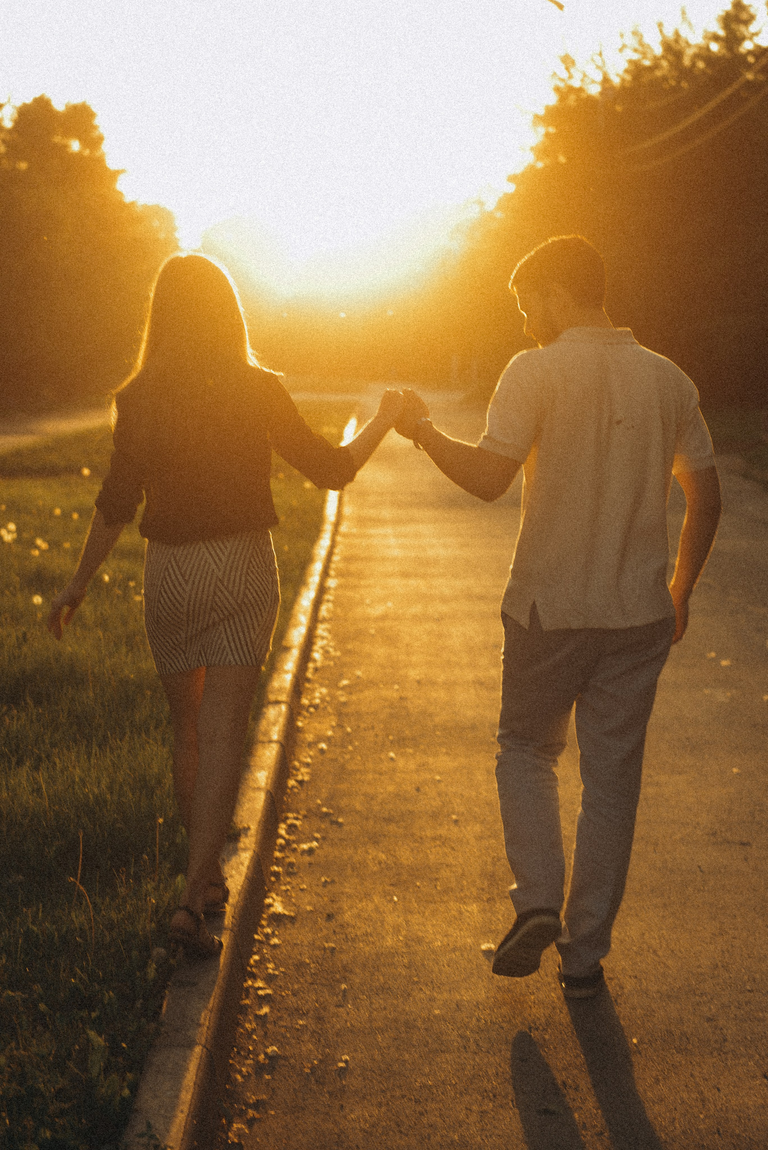 Влюбленные идут за руки по аллее в закатном солнце. Золотой час на Михайловской набережной Новосибирска, фотограф Василий Дан.