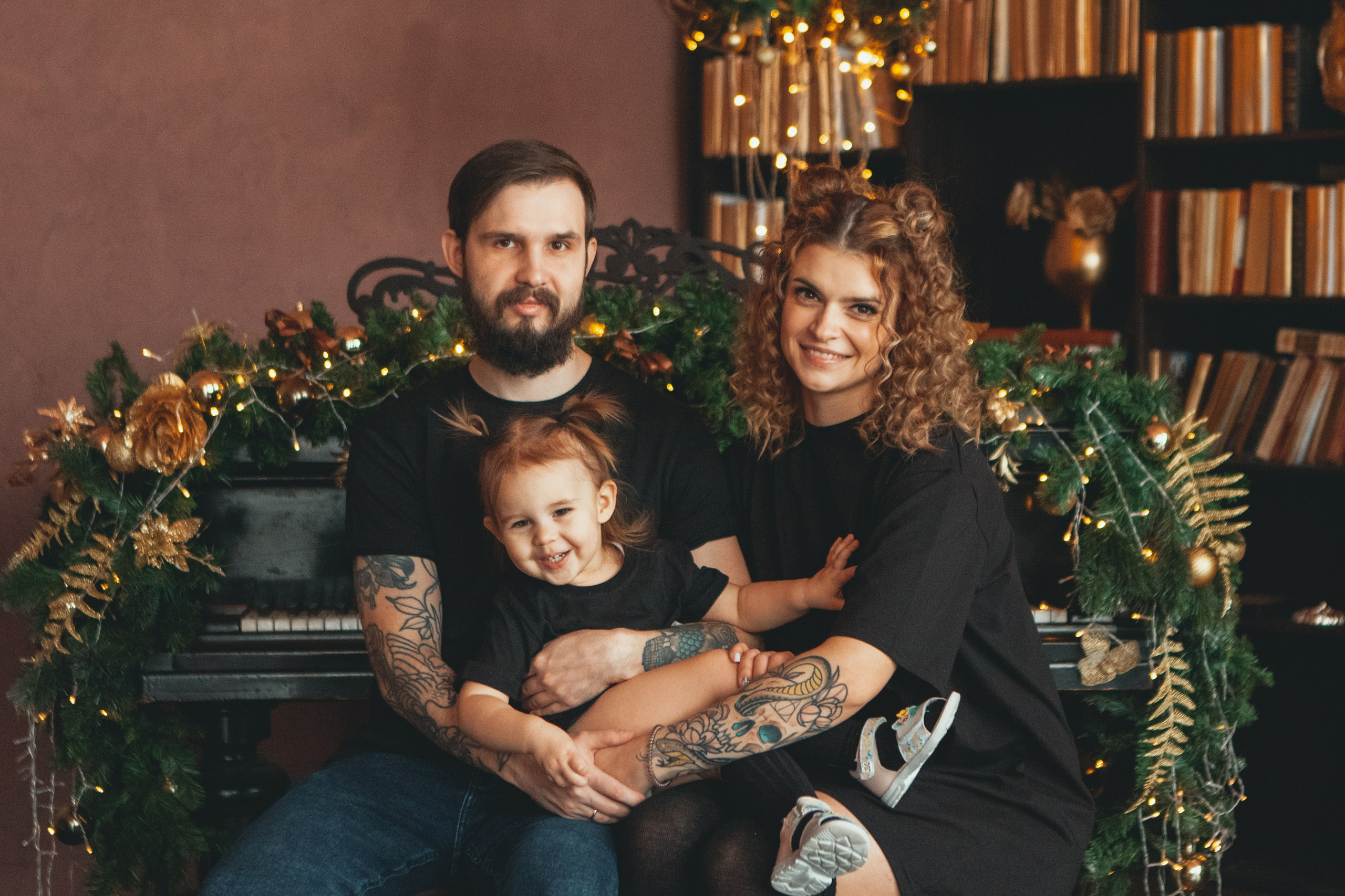 стильная семья в татуировках и в черных футболках позируют на фотосессии