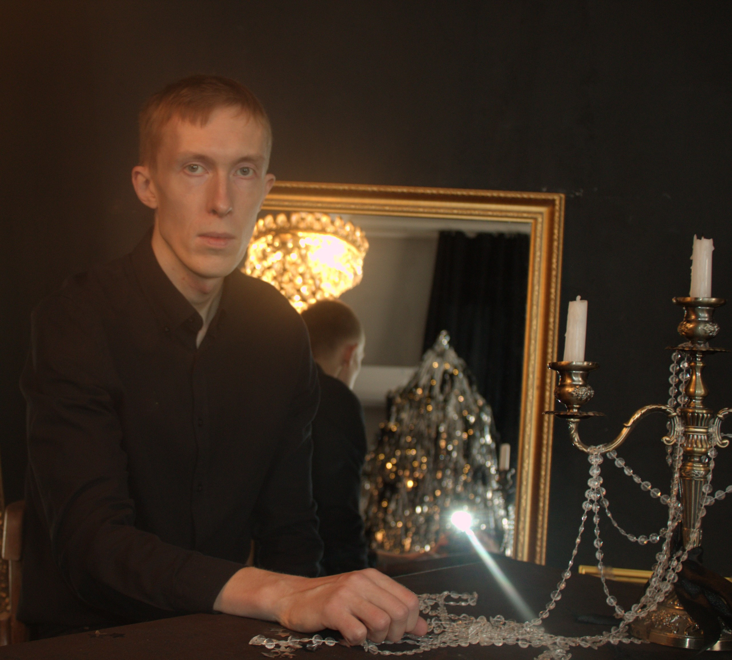 постановочное мужское фото со свечами и зеркалом