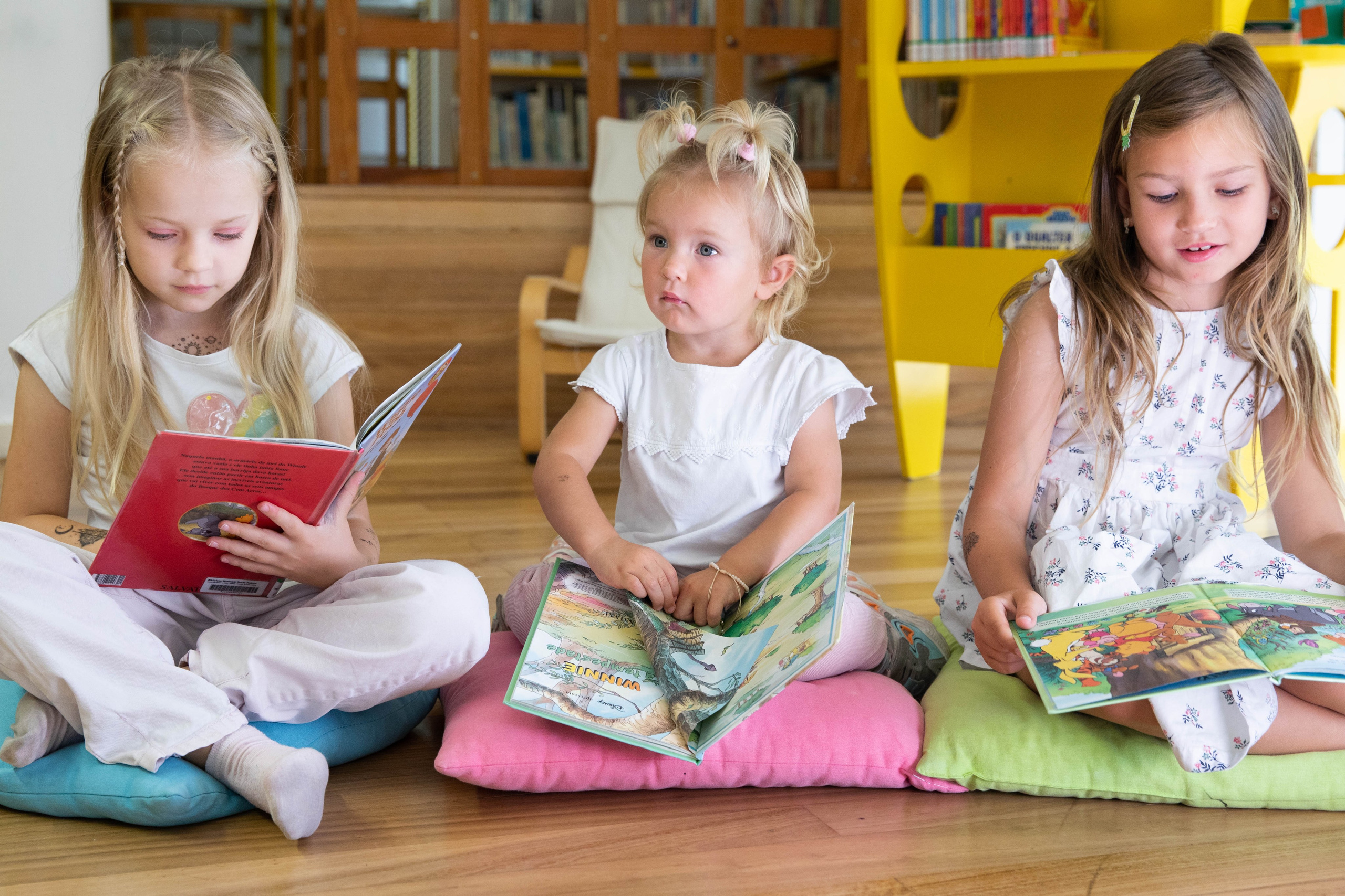 Children sitting on the floor, eagerly flipping through picture books