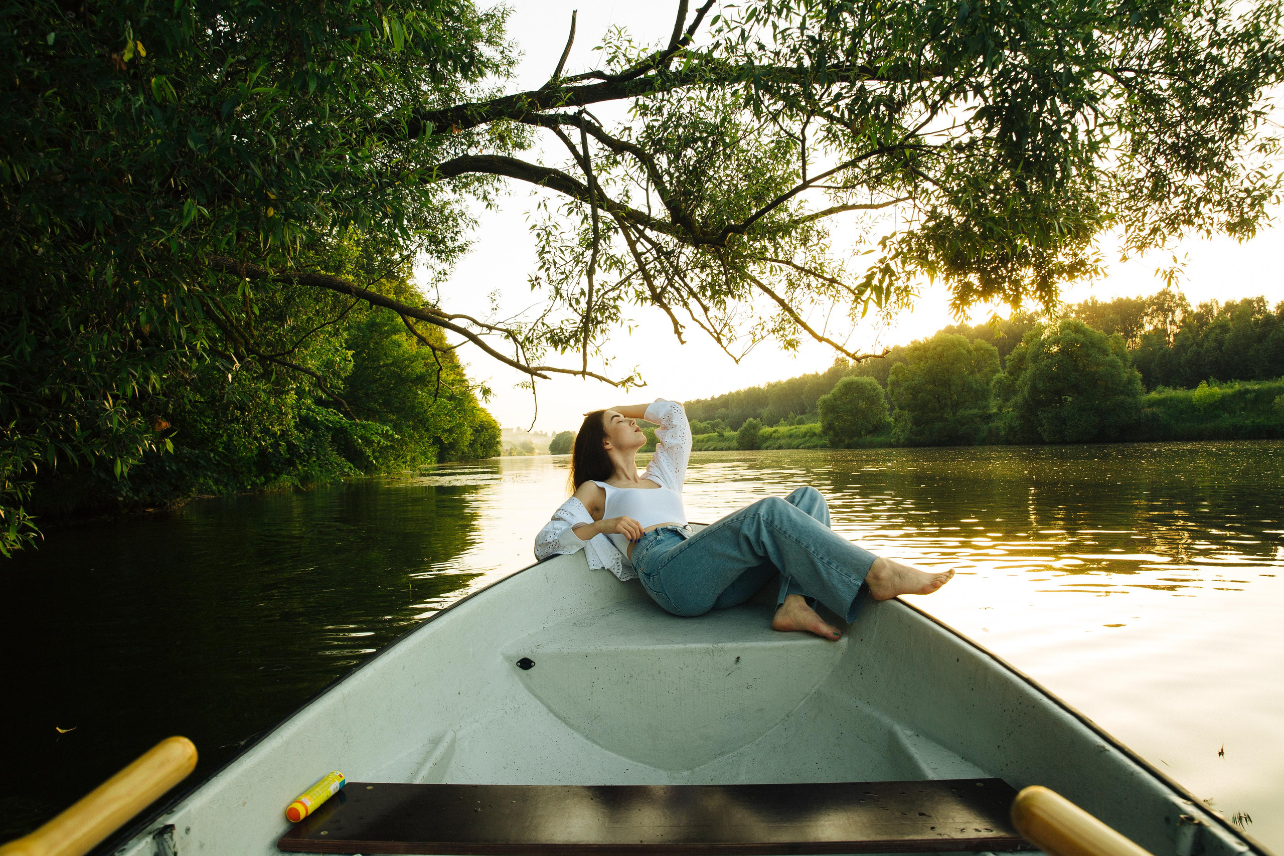 Девушка в лодке на закате на реке