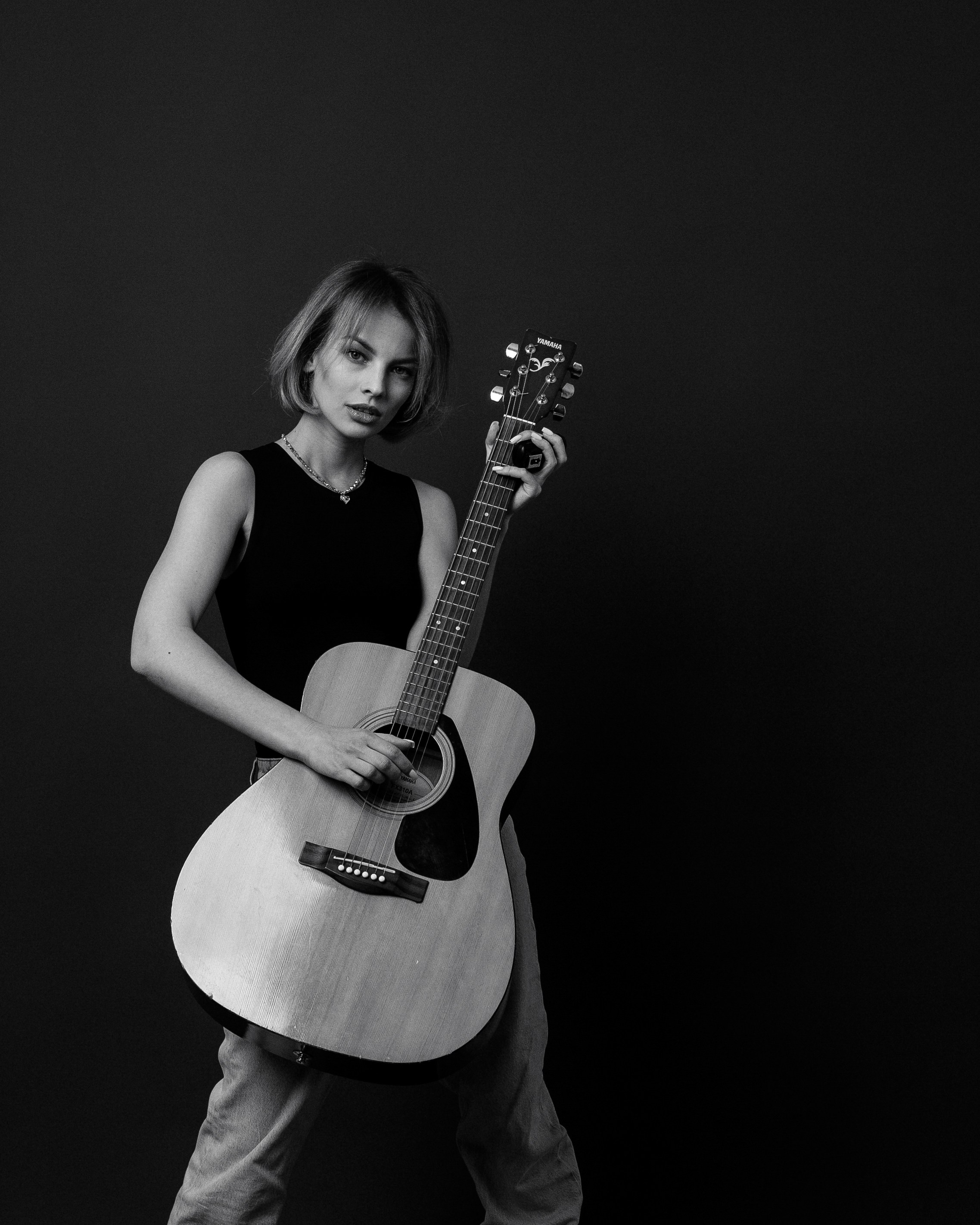 Девушка с акустической гитарой в черно белой фотосессии без фотографа