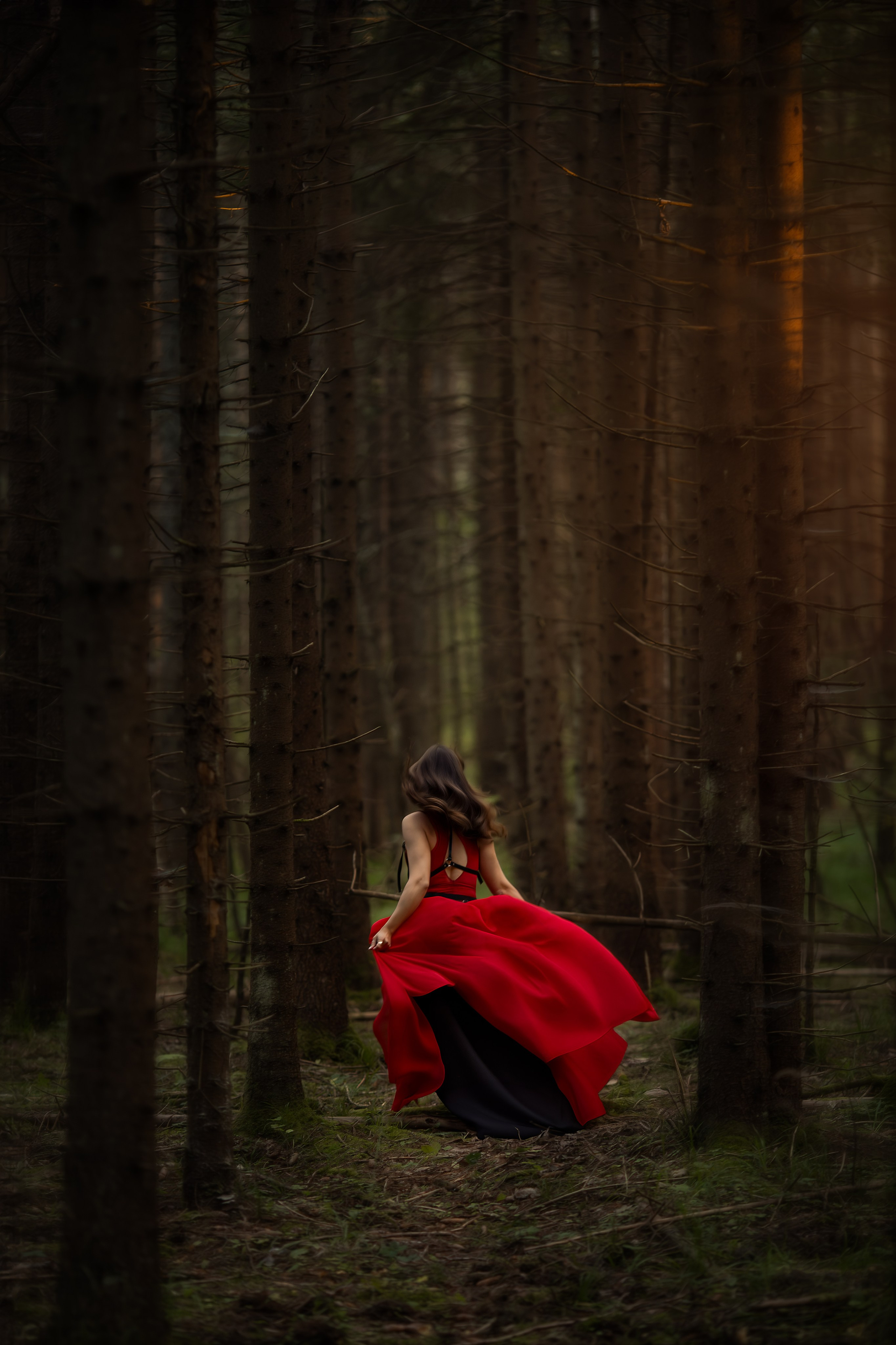 Девушка в длинном красном платье идёт по тёмному лесу, вокруг густая зелень и уходящая в глубину тропа, создавая атмосферу сказки и тайны.