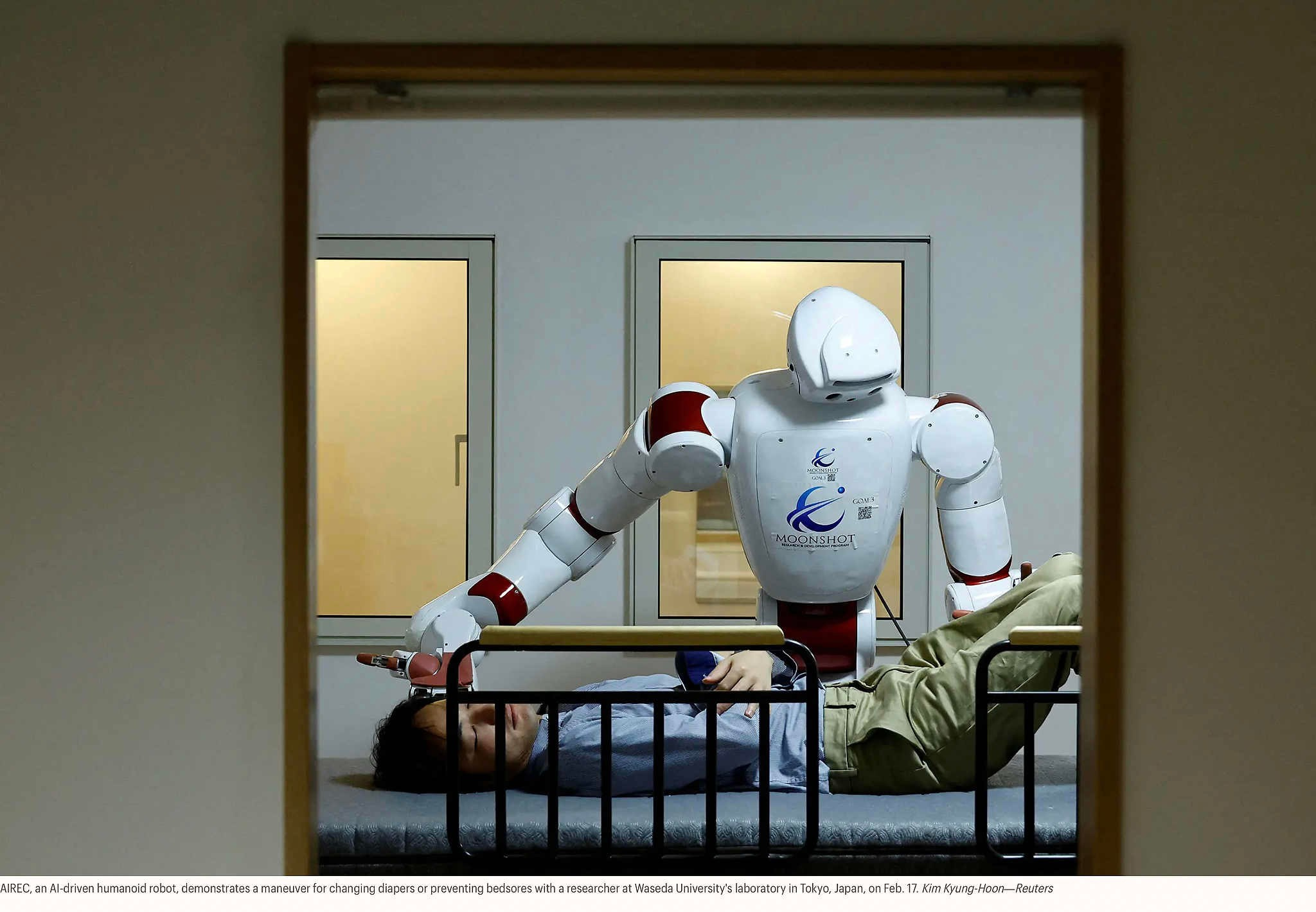 AIREC, человекоподобный робот с искусственным интеллектом, демонстрирует исследователю из лаборатории Университета Васэда в Токио, Япония, 17 февраля, как менять подгузники или предотвращать появление пролежней. Ким Кён Хун — Reuters