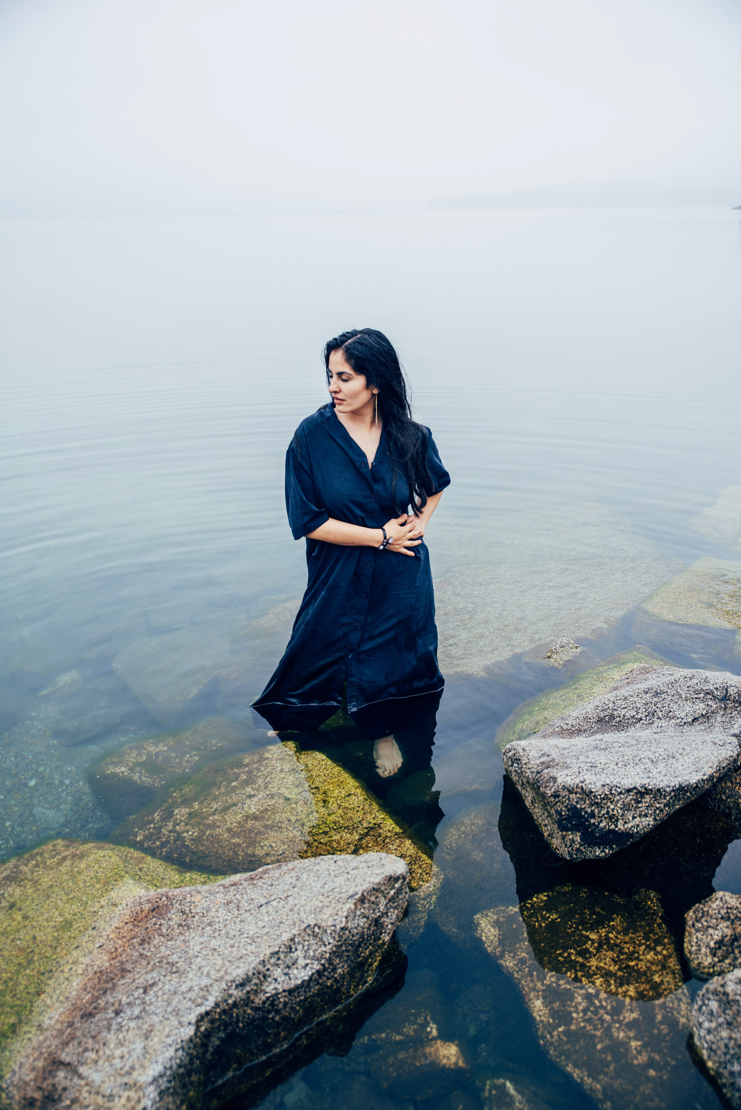 девушка стоит в воде у берега