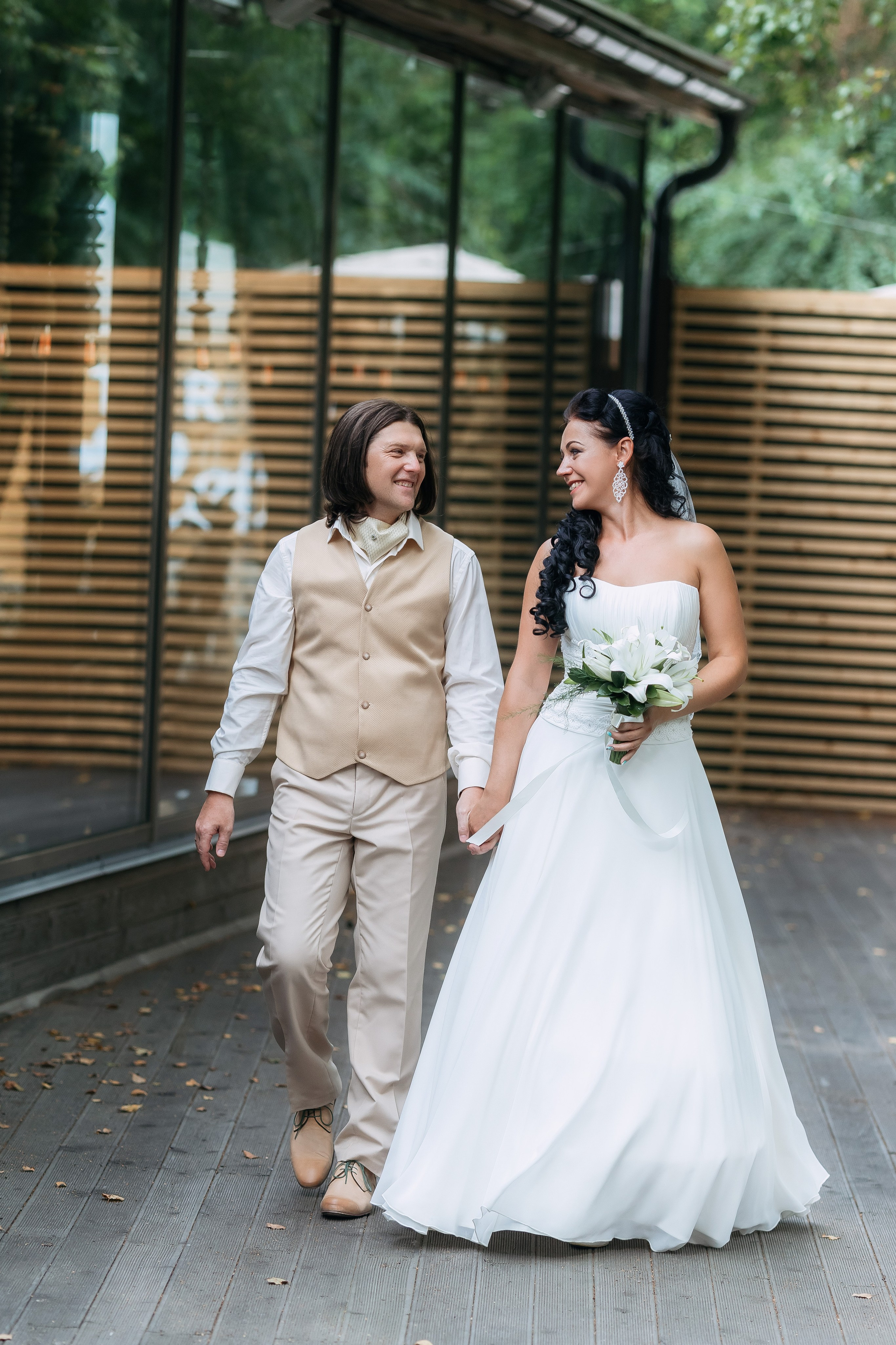 Свадебная фотосессия со зрелой парой, гуляющей на фоне ресторана в Уссурийске