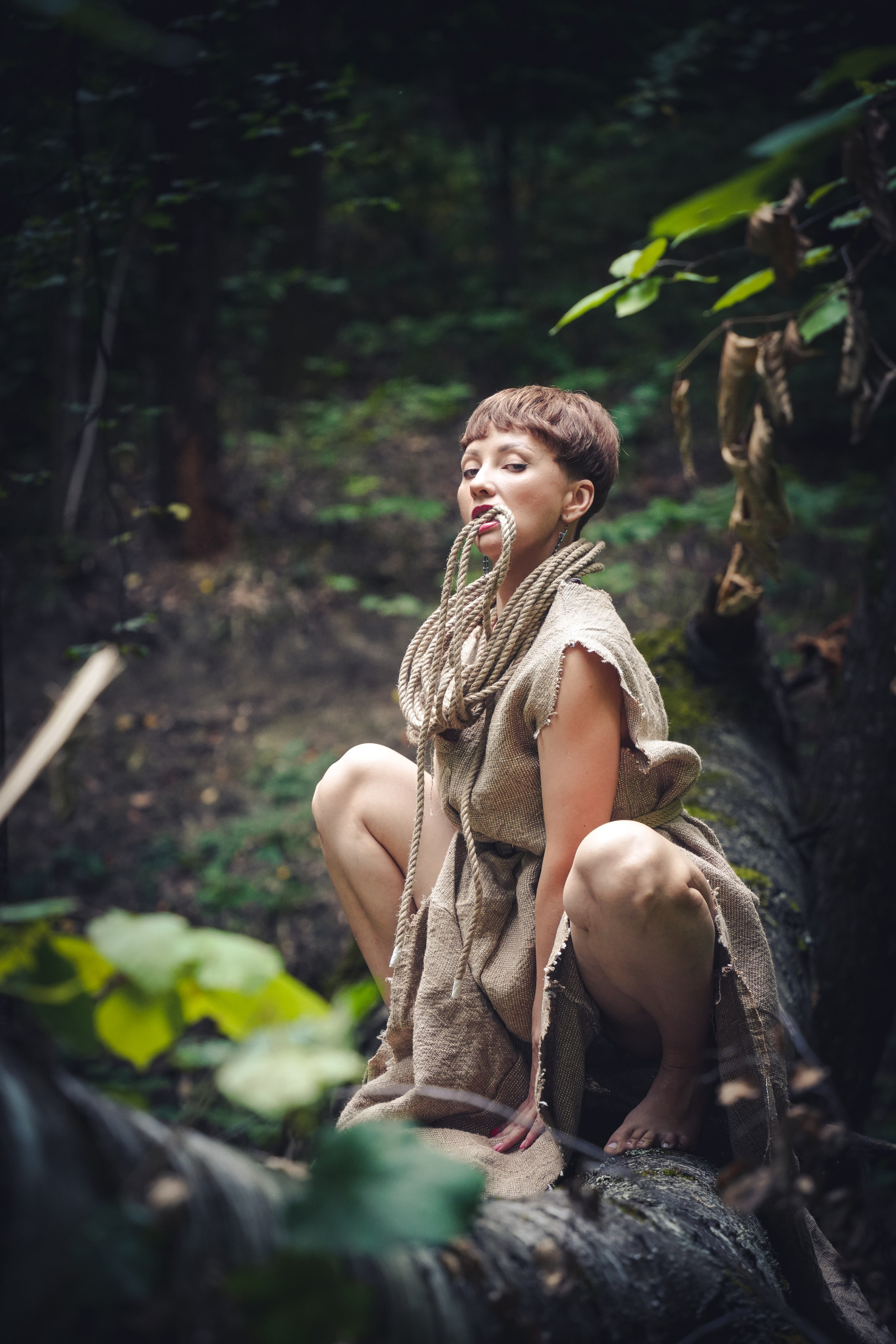 Портрет девушки с веревкой в зубах и одежде из мешковины