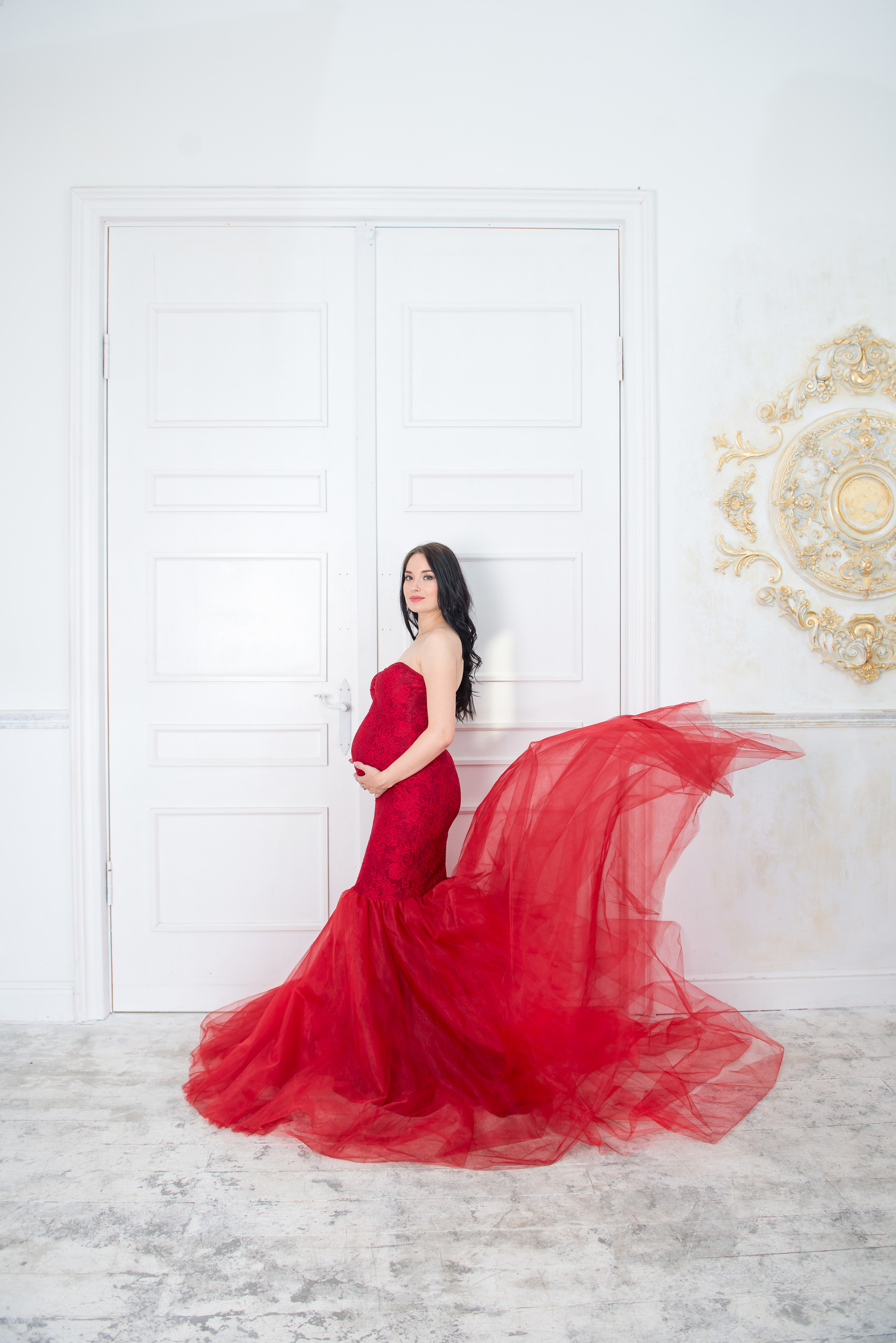 Девушка в положение в красном платье с летящем шлейфом