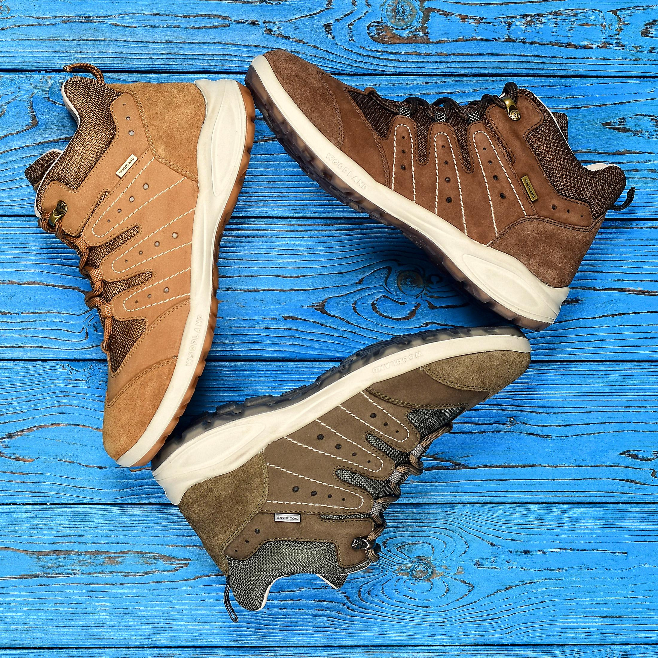 Коричневые ботинки с белой подошвой на синем деревянном фоне