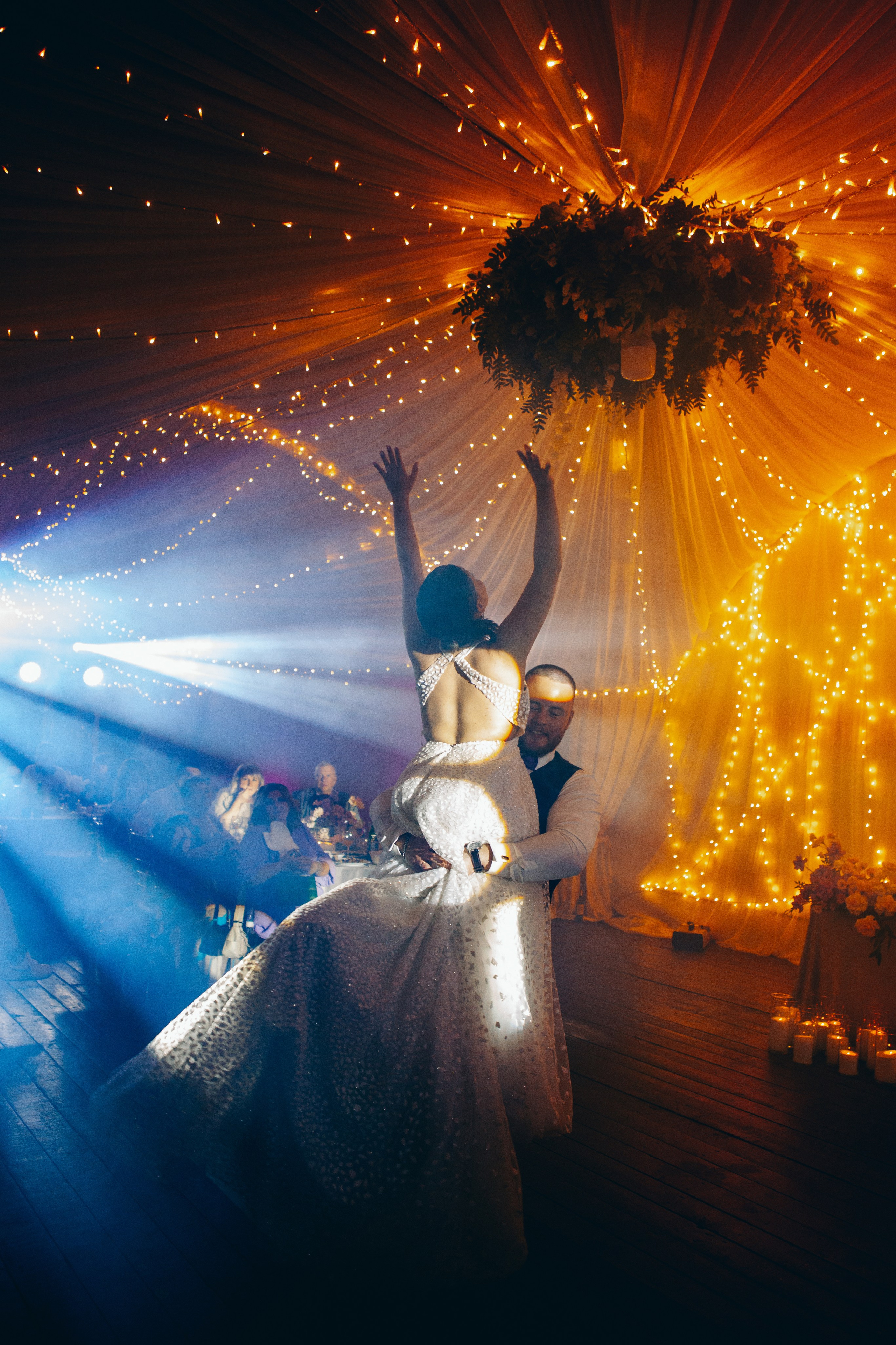 жених носит на руках невесту на свадебном танце