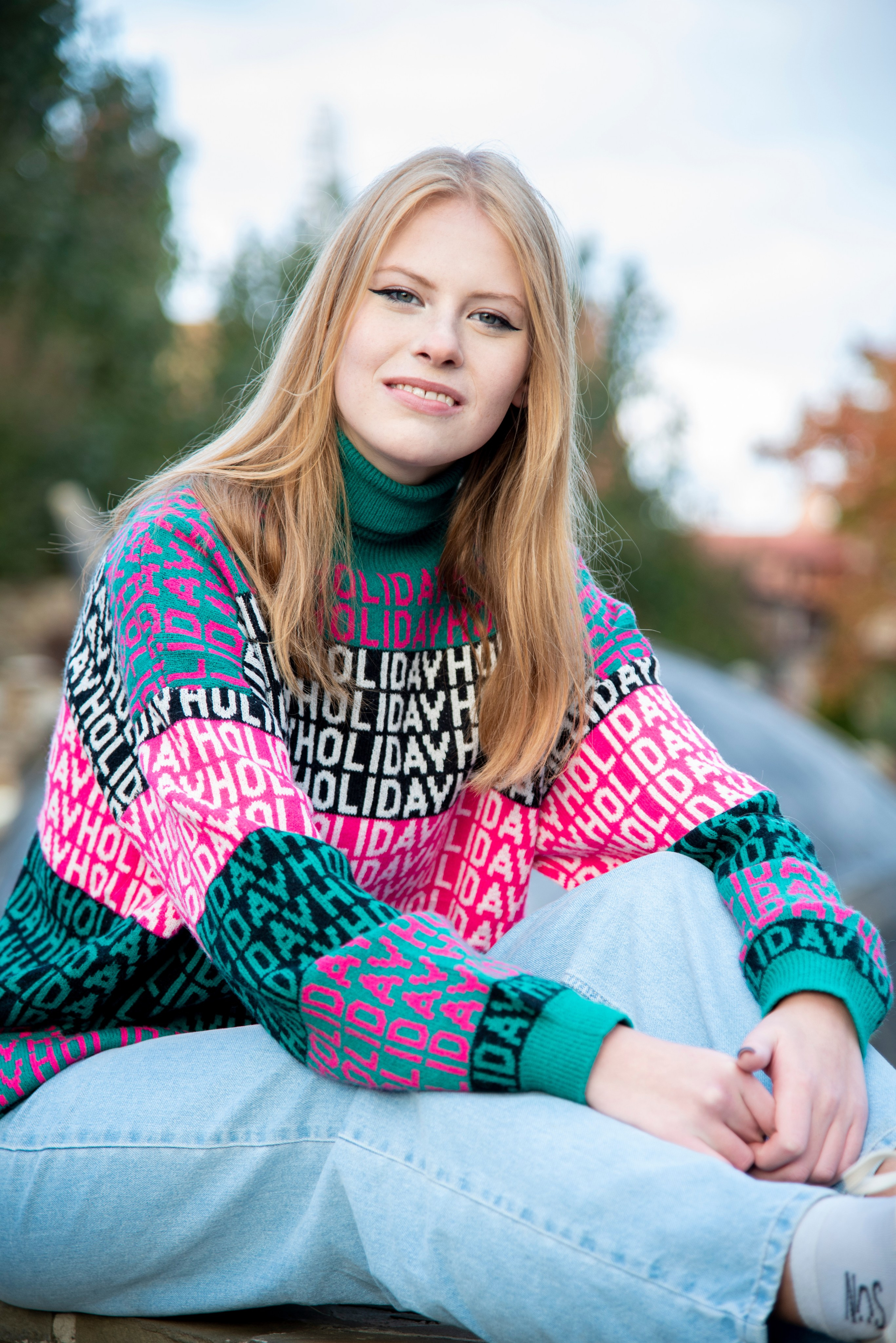 молодая девушка студентка. блондинка. длинные волосы. розово-зелёный свитер. парк Лога . осень