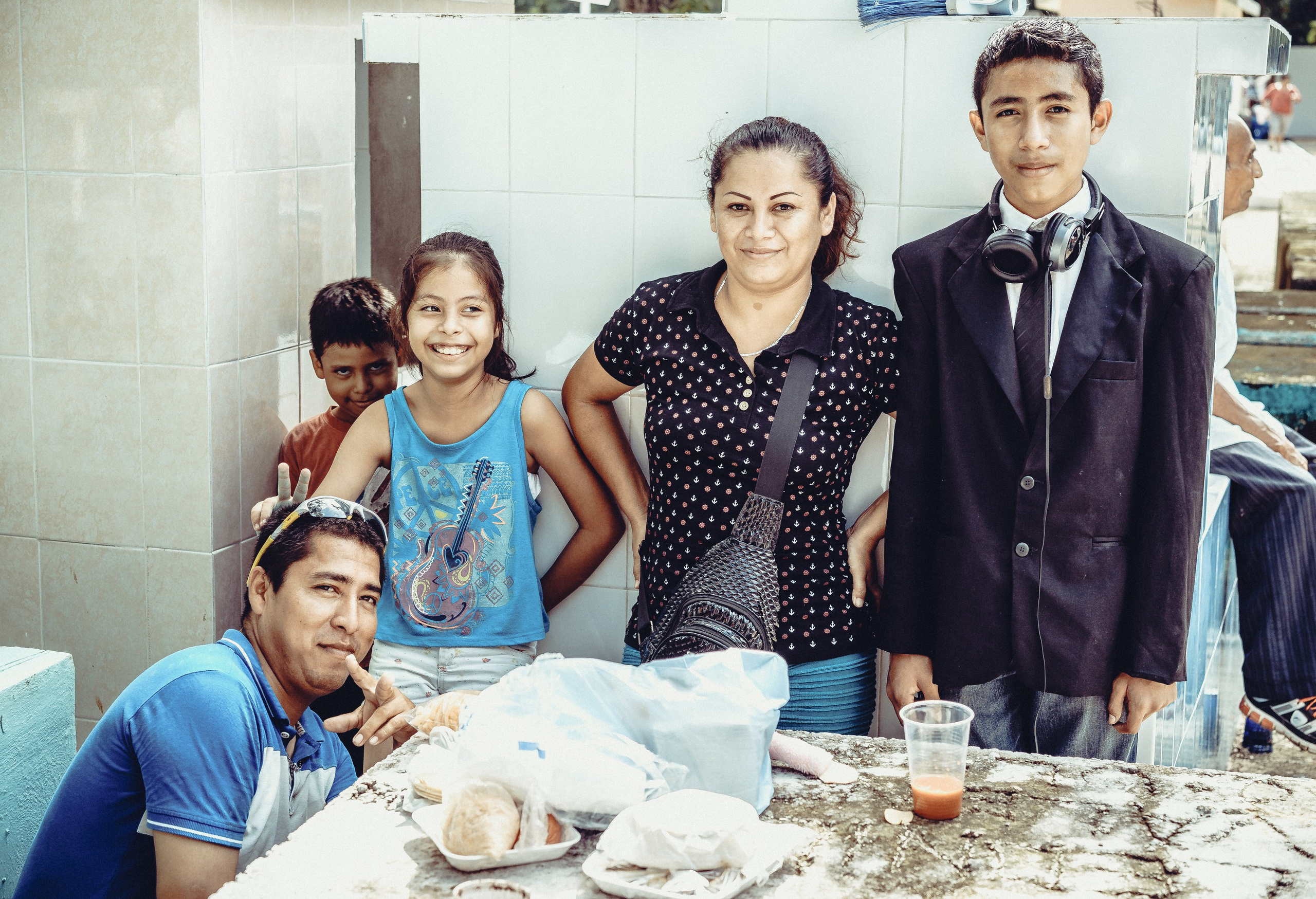 Мать с детьми на могиле родственника в День Мертвых.