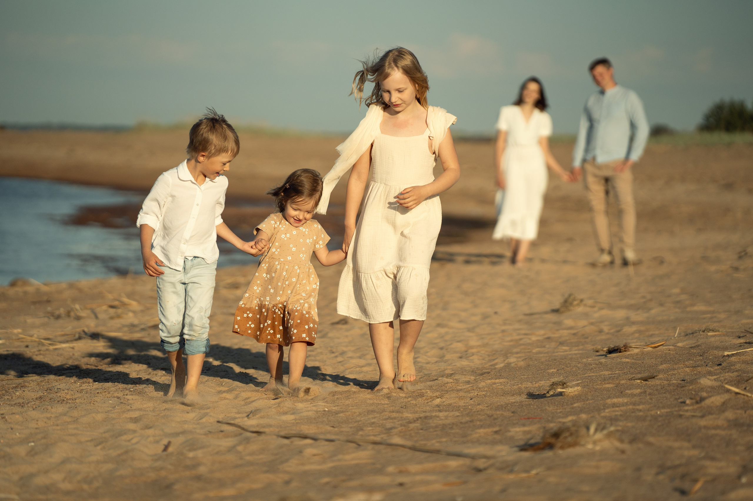 Семейная фотосессия с детьми. Родители играют с детьми на берегу Финского залива. Дети бегут от родителей, а потом бегут к ним.