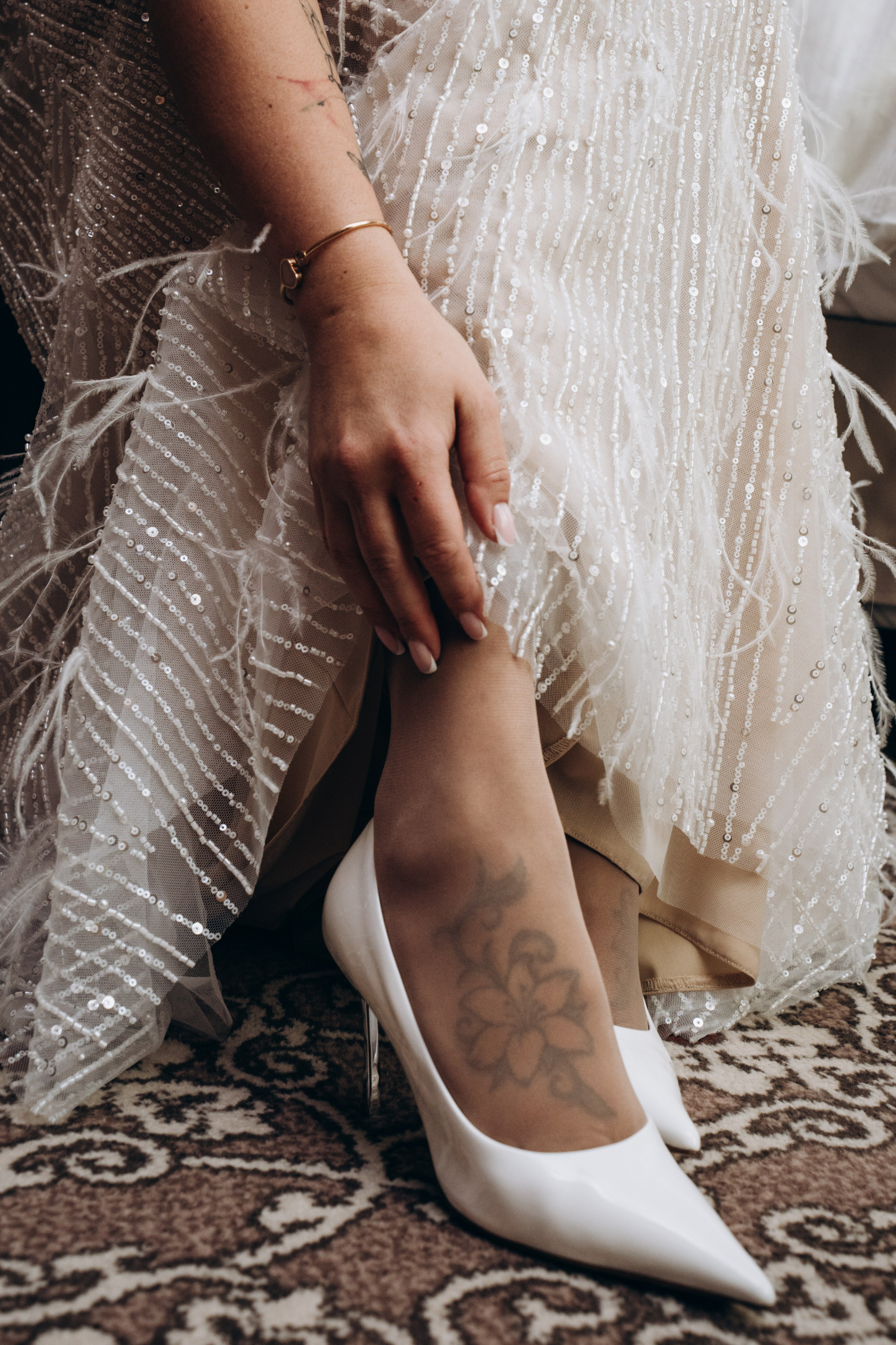 Невеста примеряет свадебные туфли в комнате с естественным светом — профессиональная фотосъемка подготовки к свадьбе в Москве.