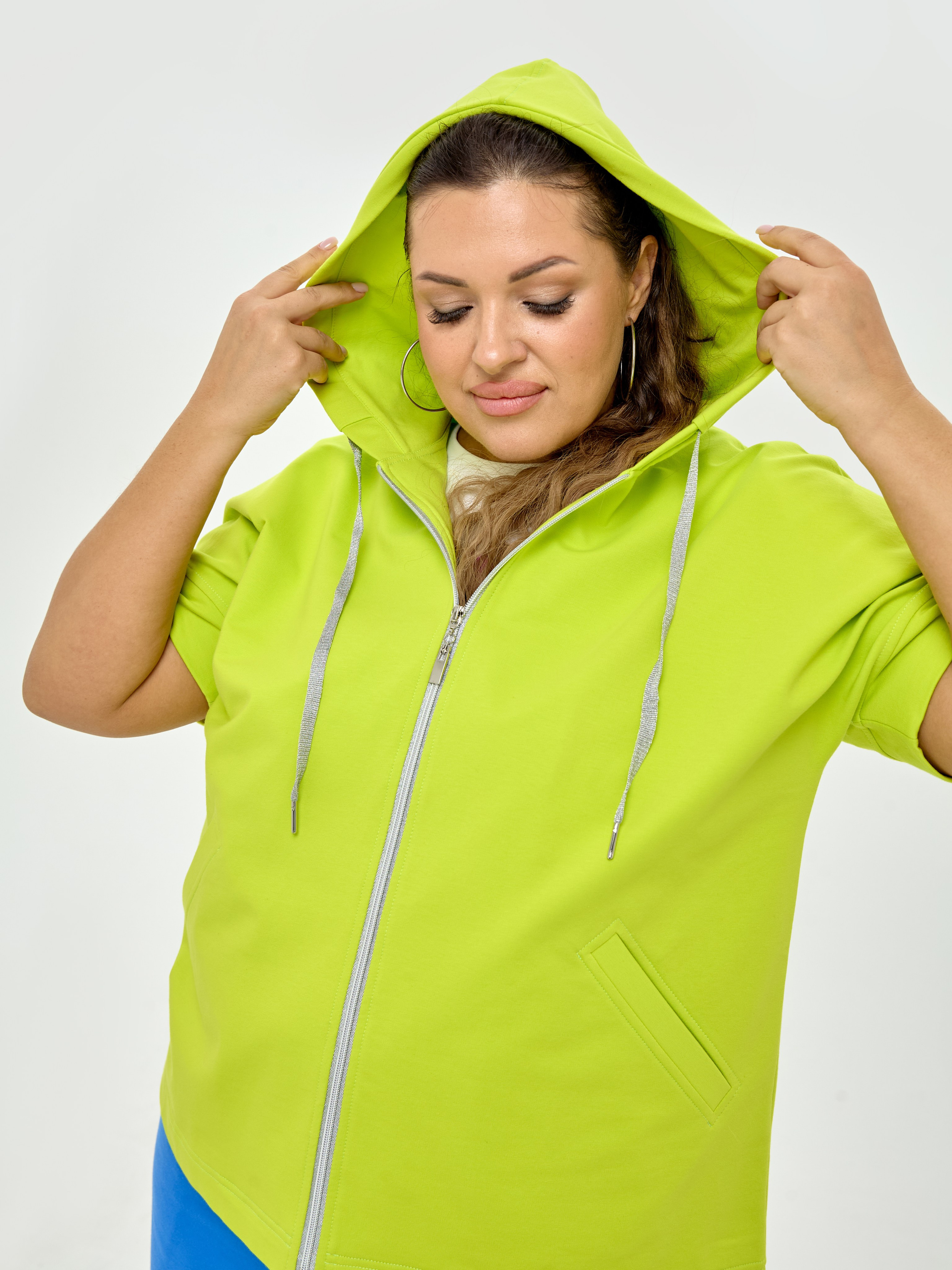 Модель Элеонора Игнатова в зелёном спортивном костюме Varra на белом фоне