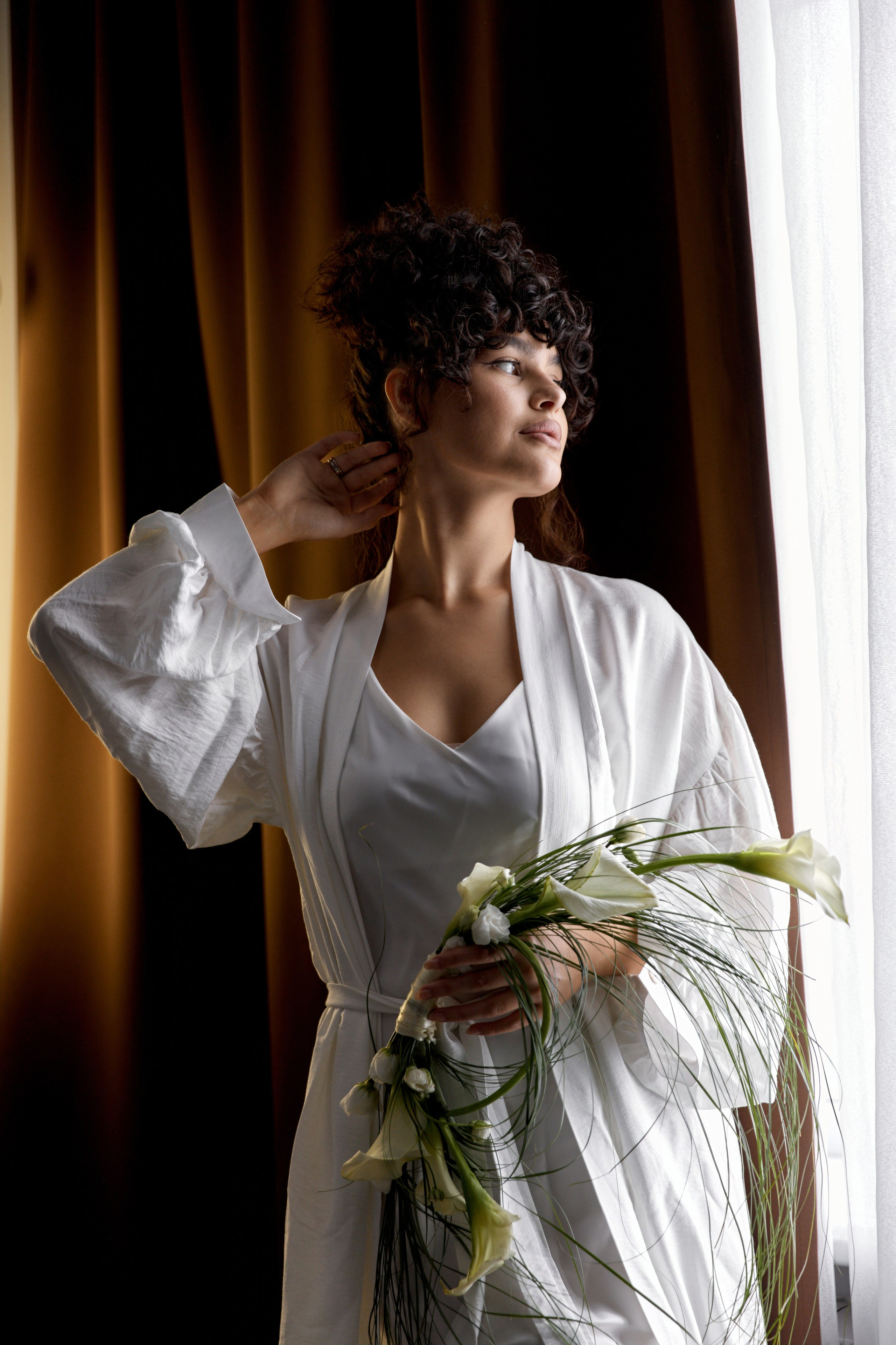 Невеста у окна с цветами в Казани. Свадебная фотосессия