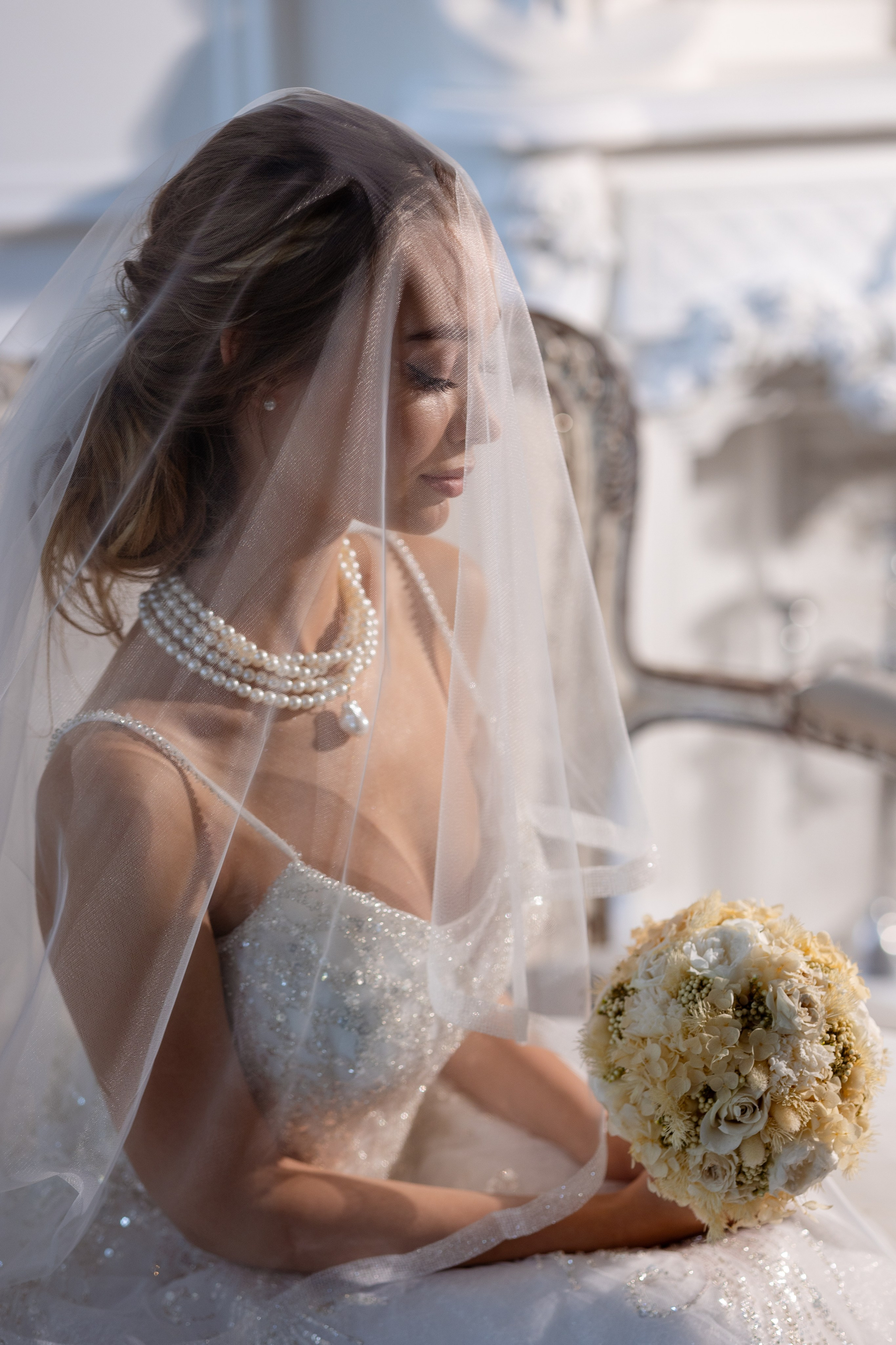 Прозрачная белоснежная вуаль покрывает голову и грудь невесты.