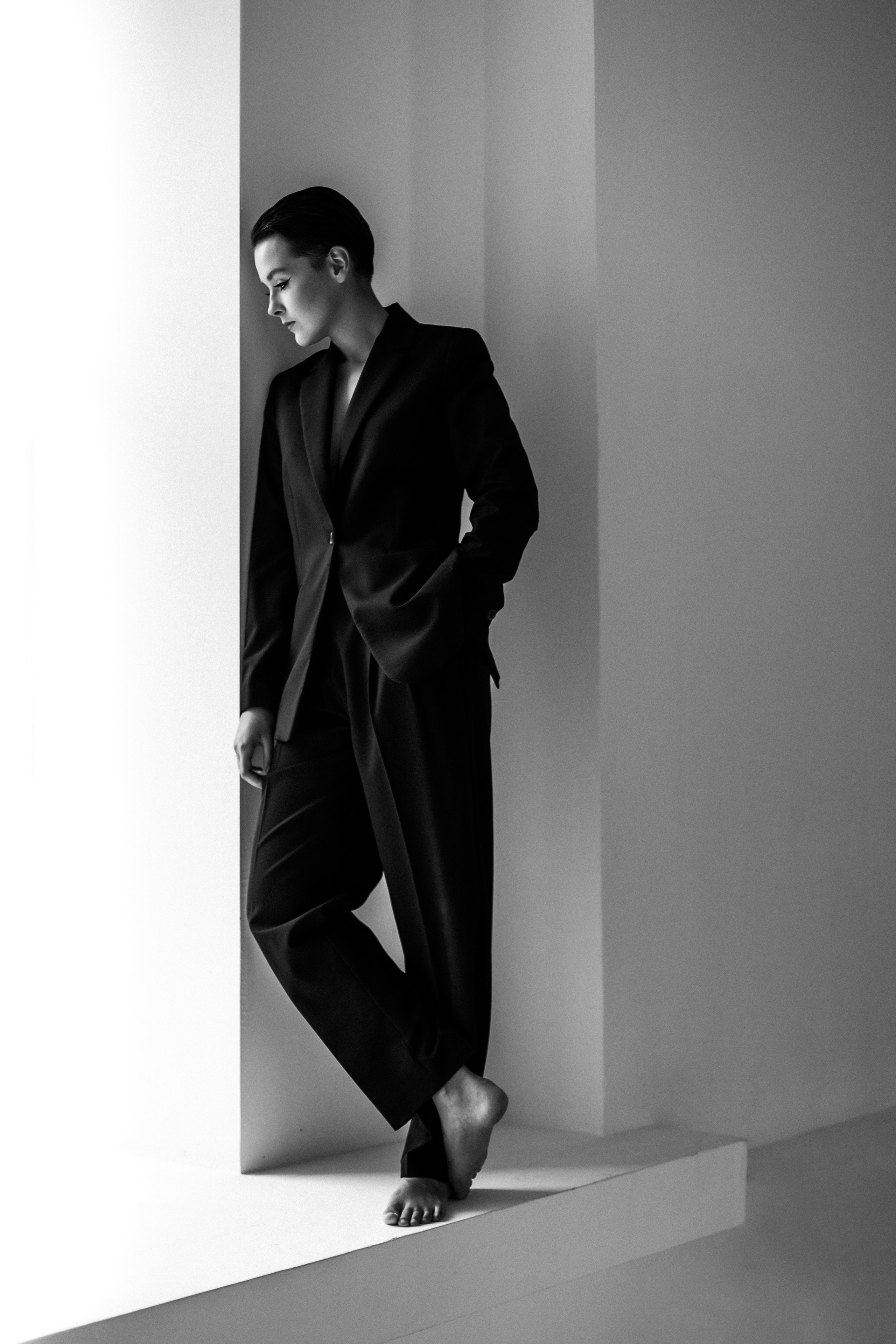 фотография девушки в мужском костюме в полный рост у окна