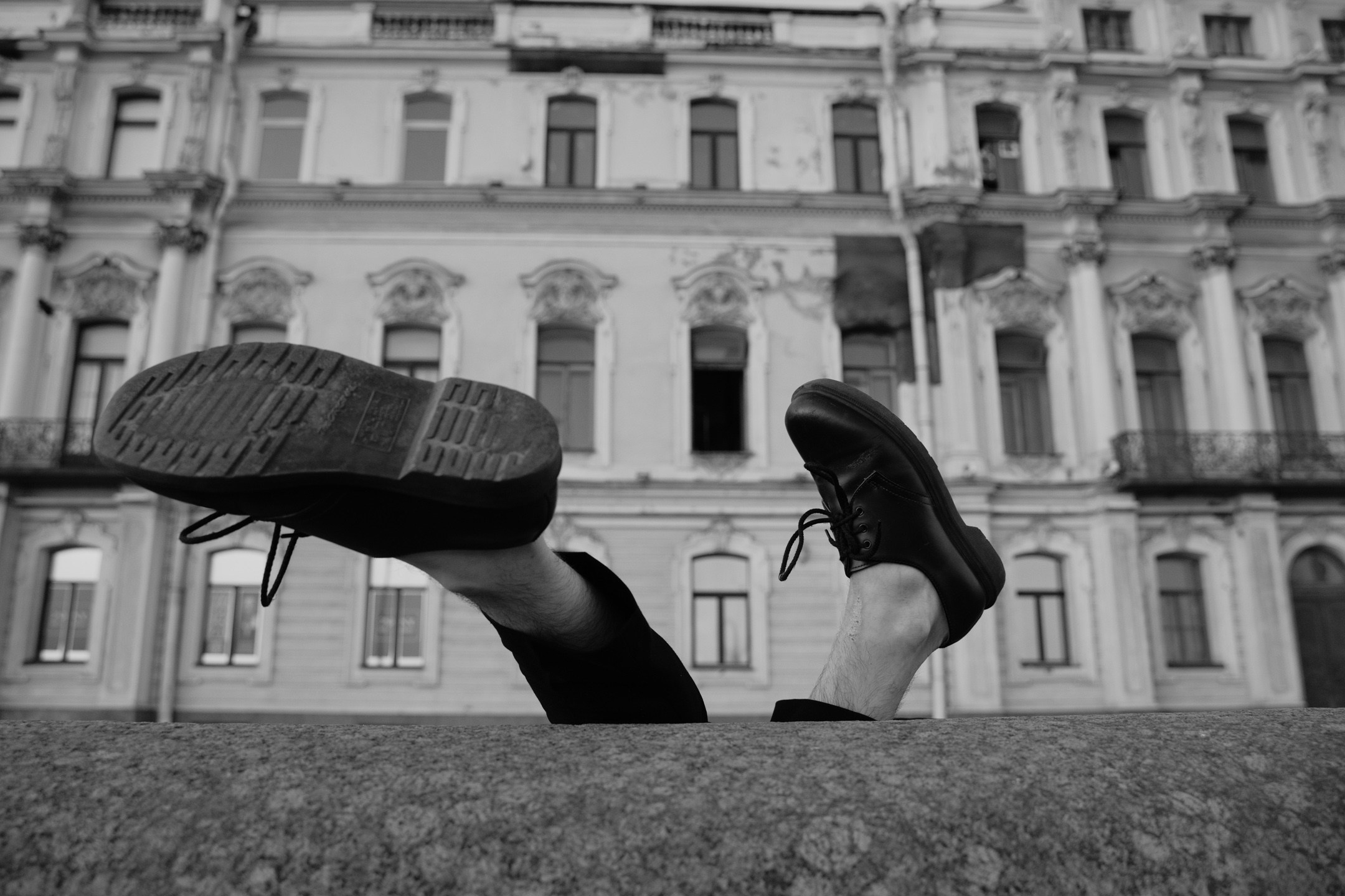 Фотография ног парня возле здания 