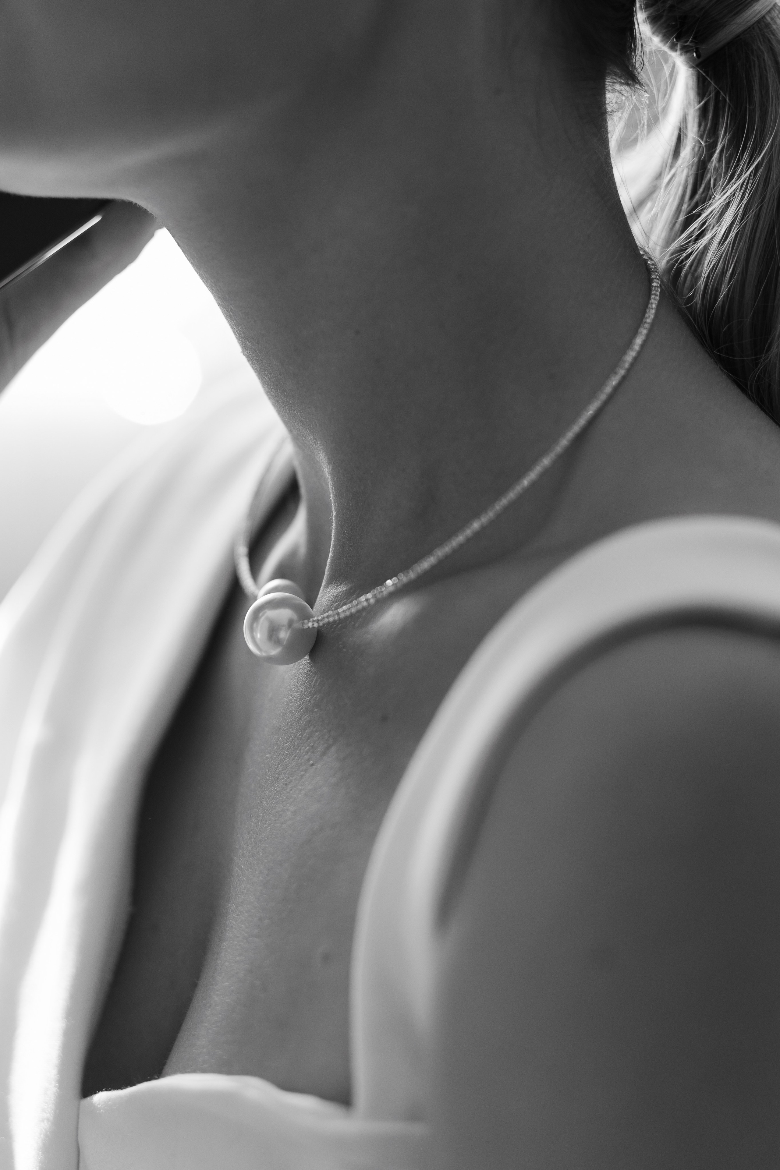 На шее невесты красивое украшение, фото в черно-белом цвете.