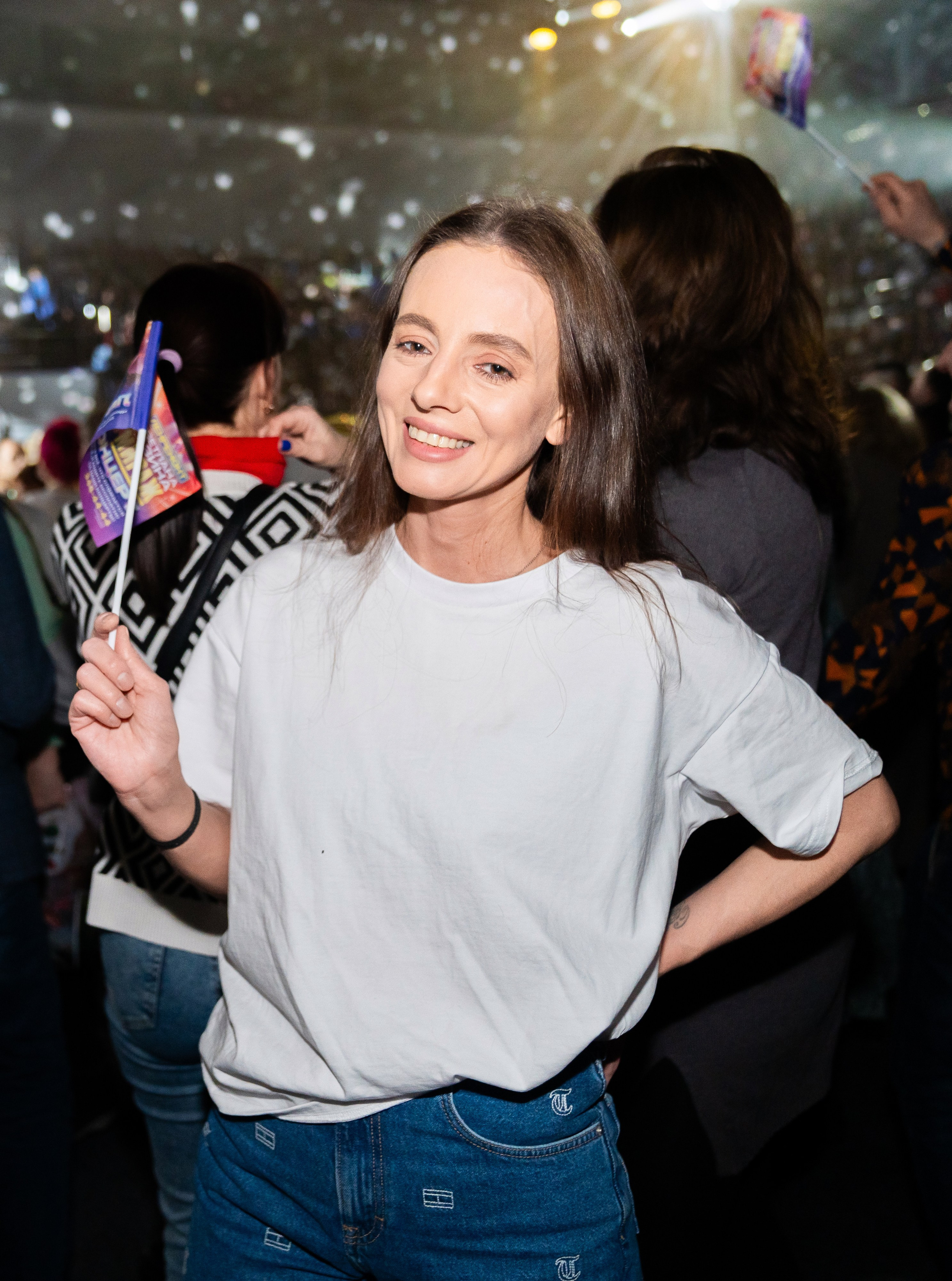 Девушка с флажком улыбается на концерте Светланы Разиной. Корпоративный праздник Ленремонт в КСК Арена. Фото Евгения Мальцева.