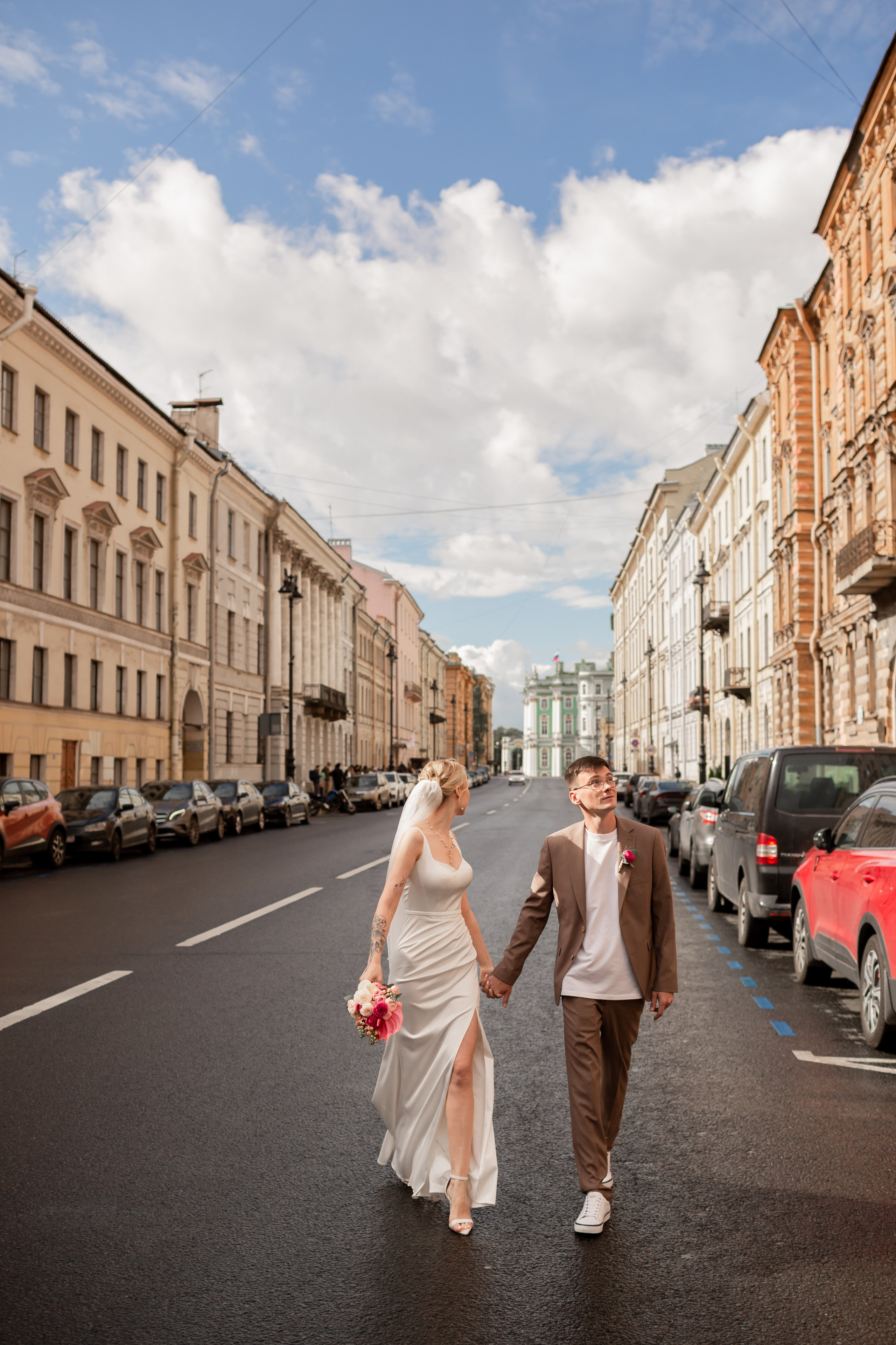 Жених и невеста гуляют по красивой улице Петербурга.