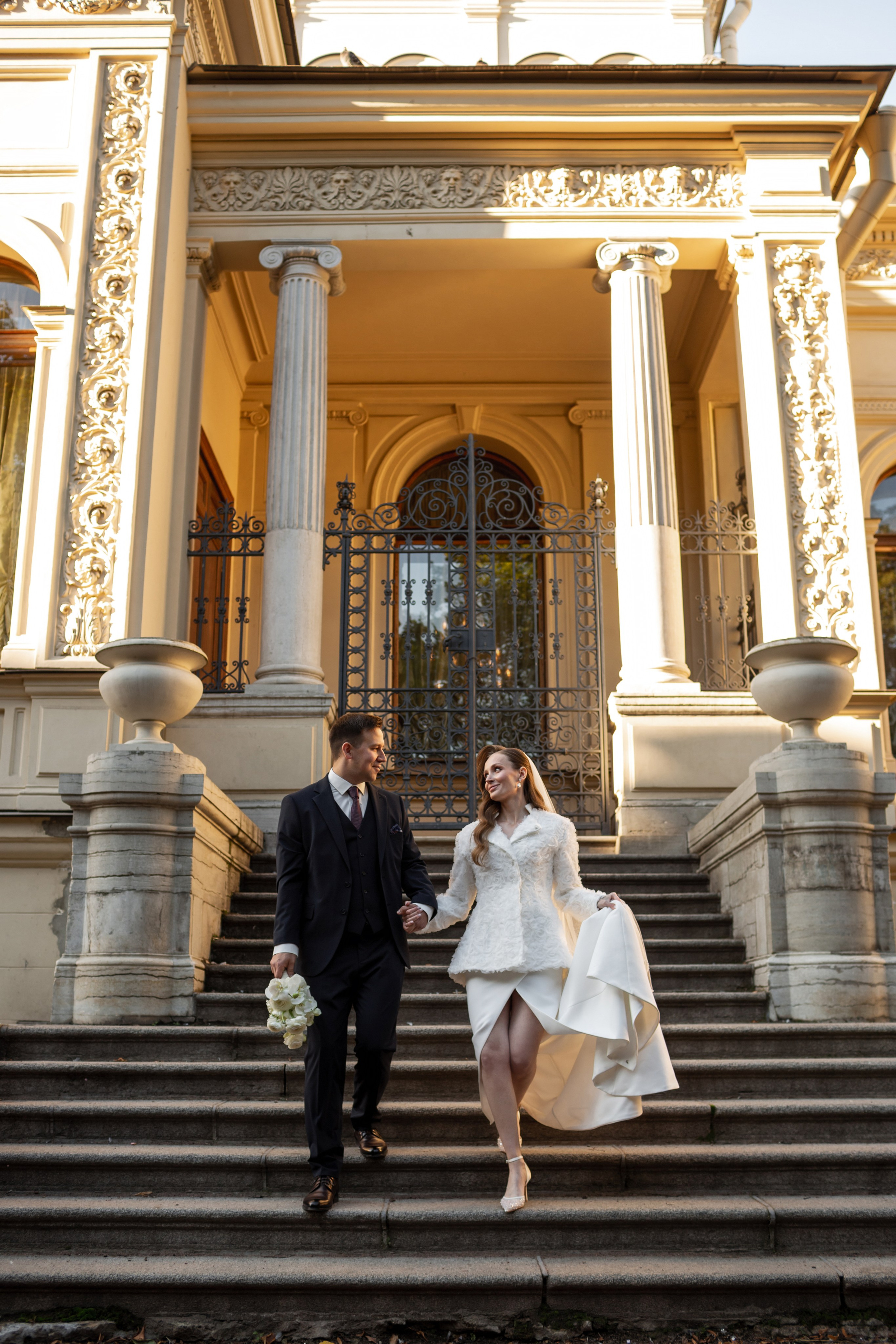 Жених и невеста красиво спускаются по дворцовой лестнице.
