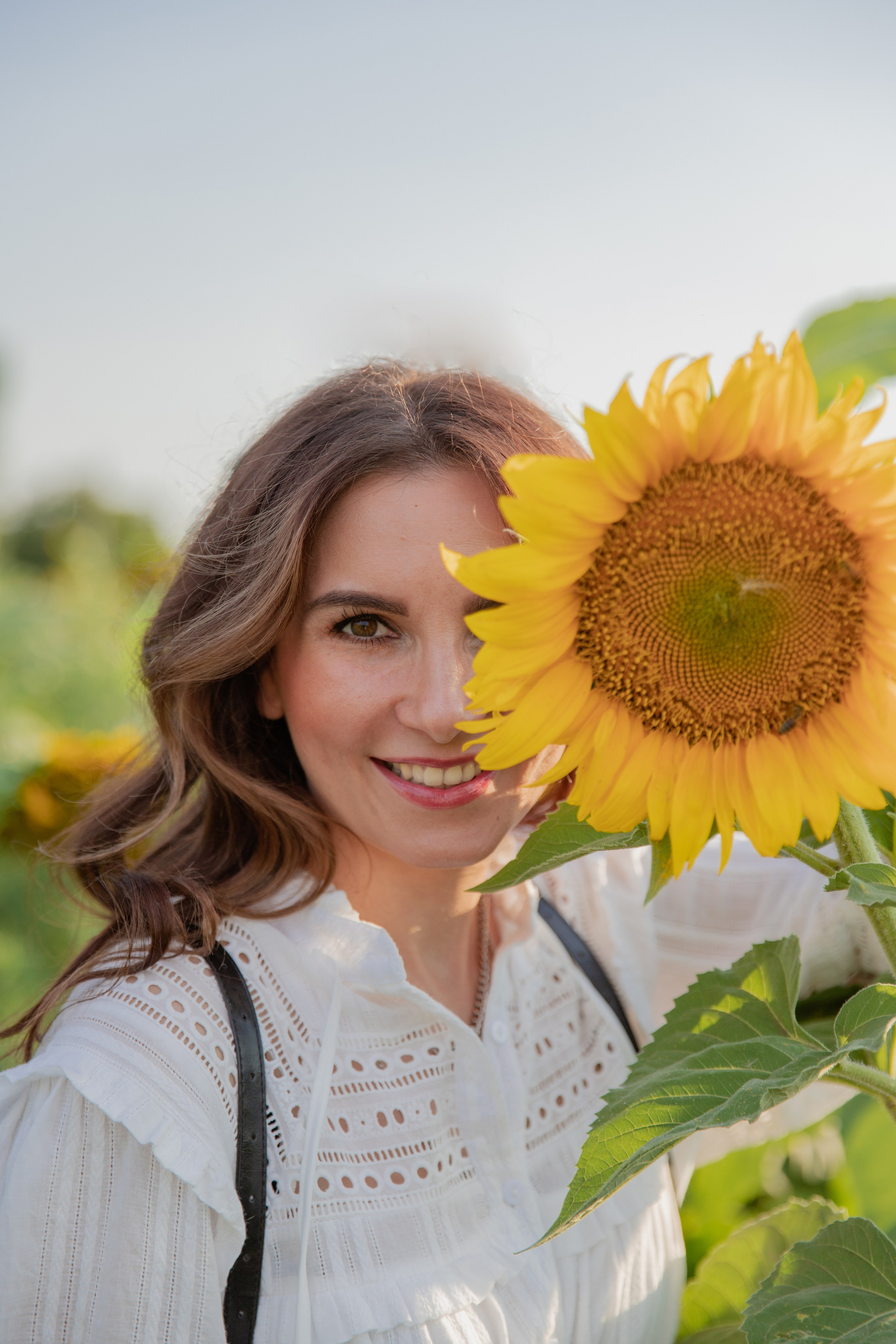 Крупный план — довольная девушка подставила подсолнух к лицу , , олицетворяющие простую радость природы и беззаботность