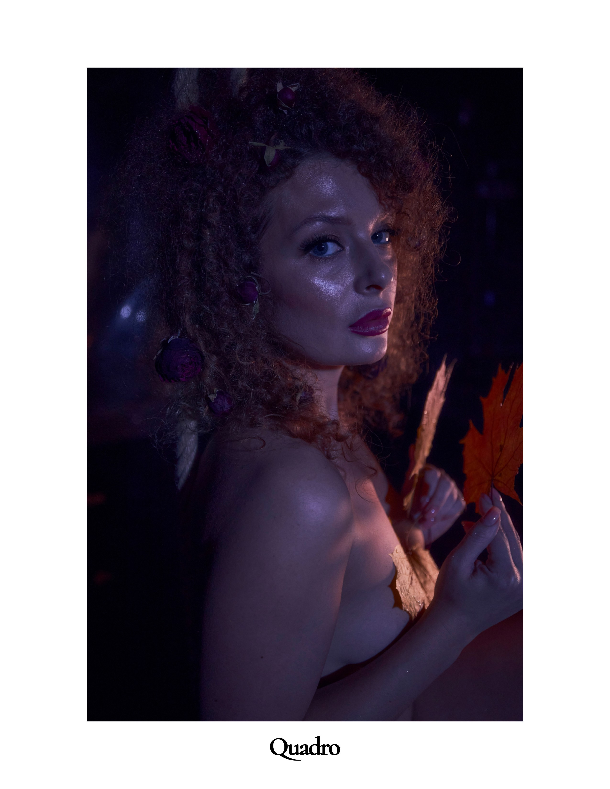 Портрет красивой девушки с кудрявыми волосами в цветном свете  и осенними листьями в стиле ню