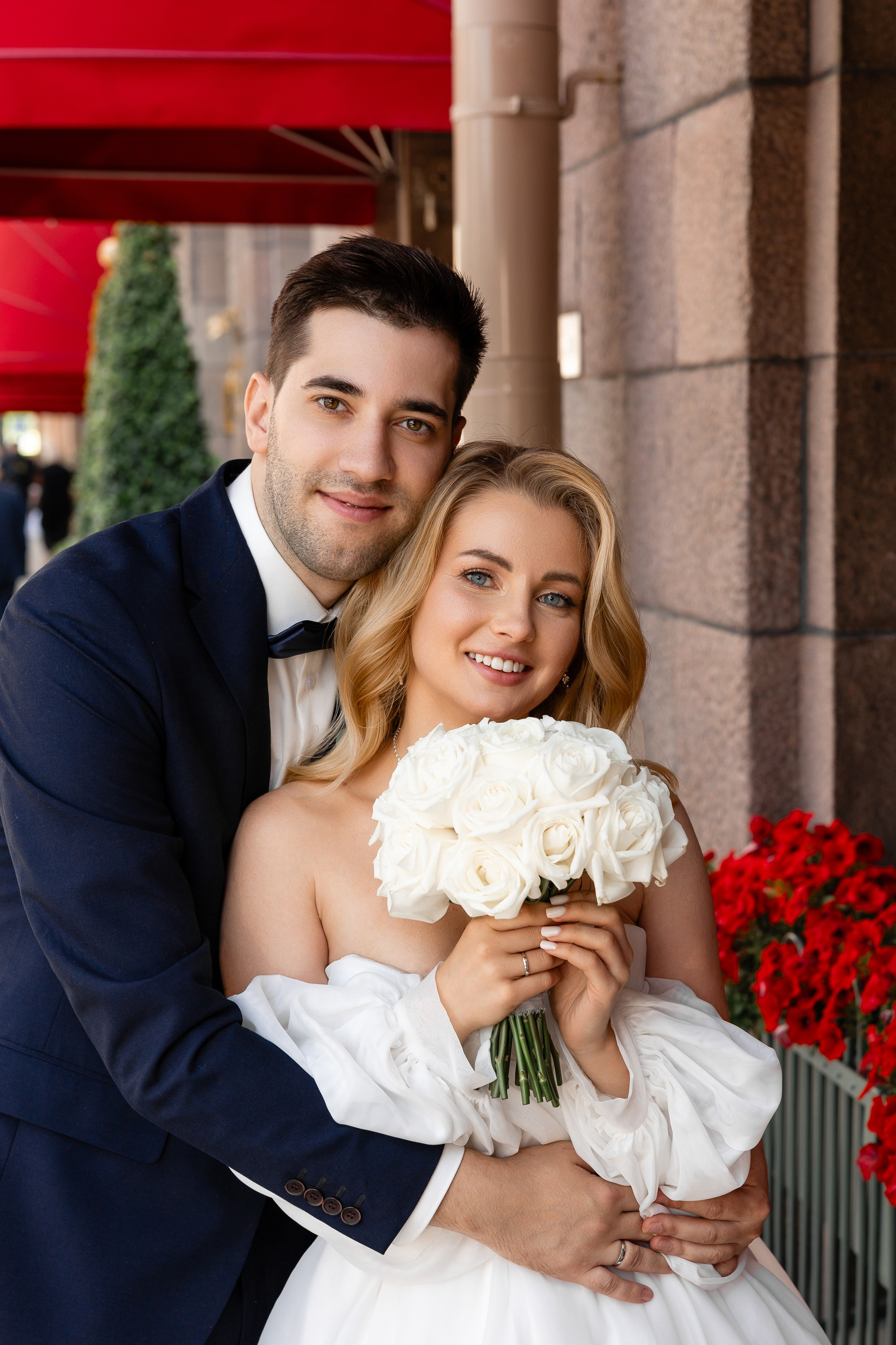 Жених и невеста под красным козырьком гостиницы Астория