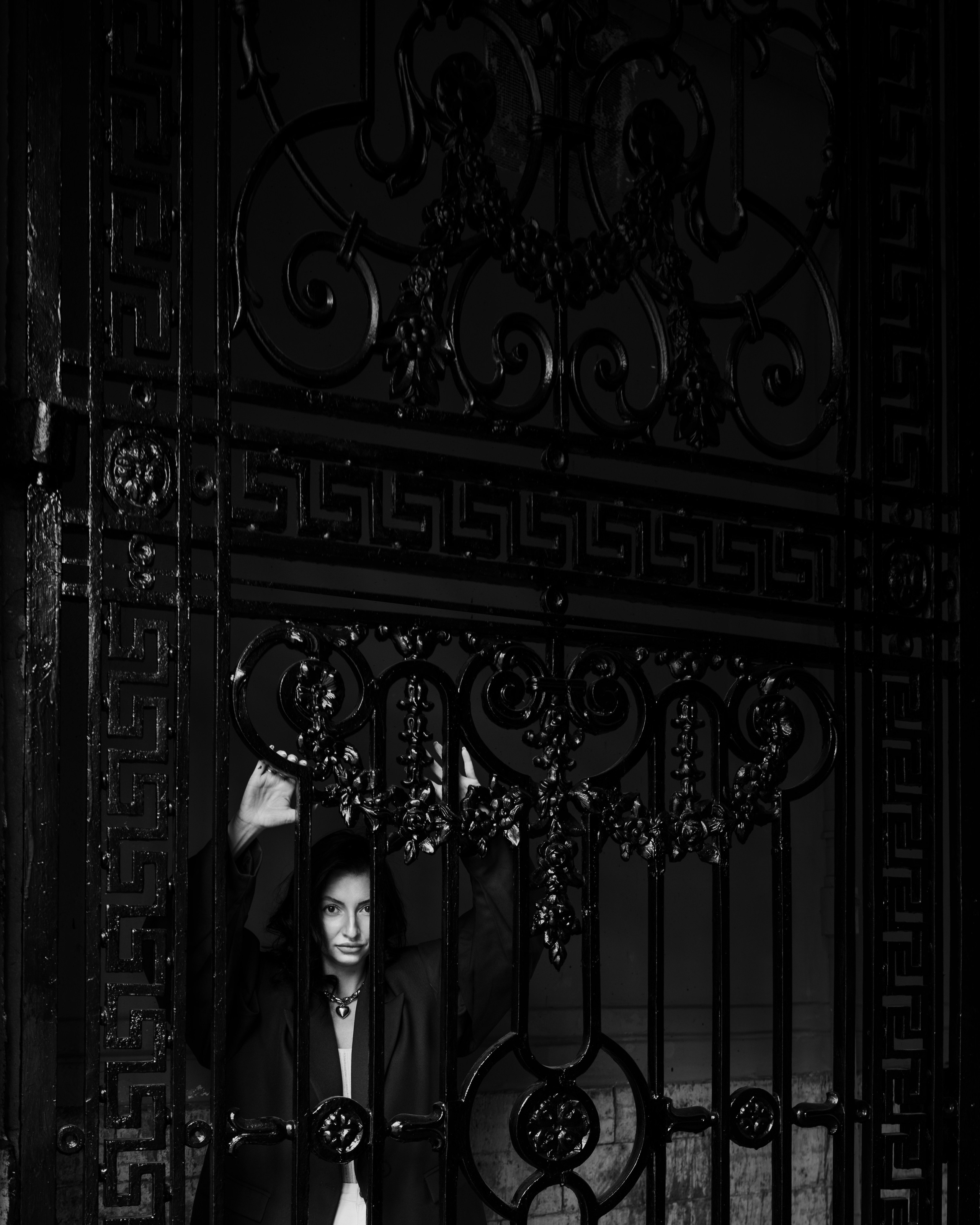 женский петербургский портрет за историческими коваными воротами