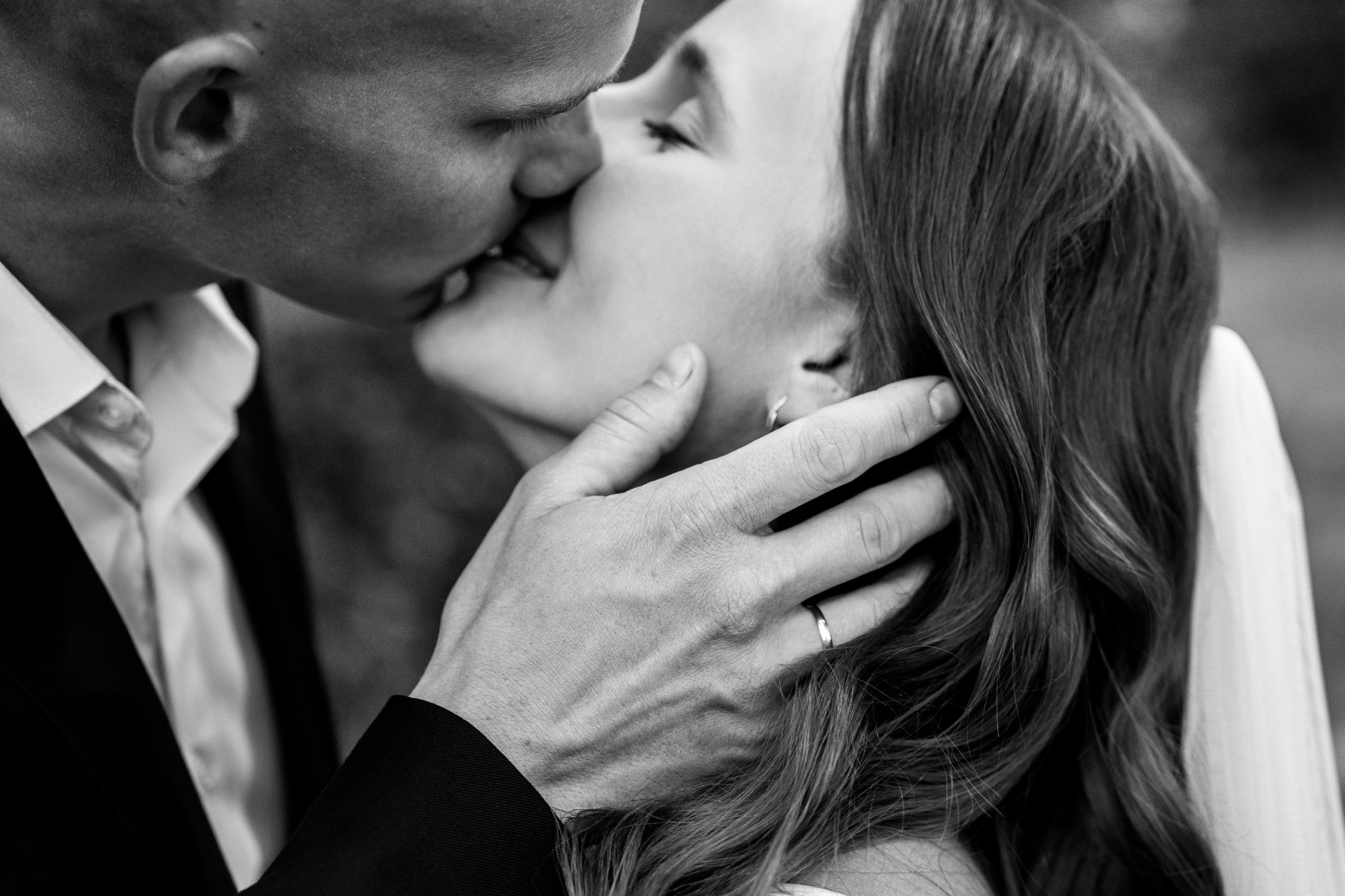 Супруг целует свою невесту. Черно-белая фотография.