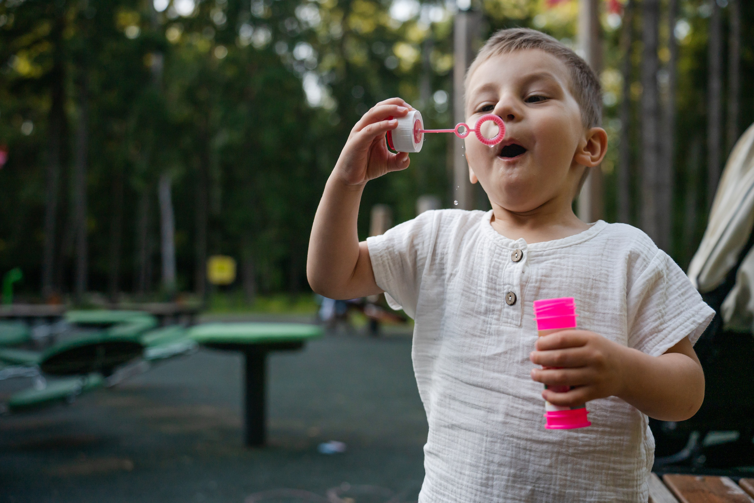 ребенок дует мыльные пузыри. теплая атмосферная фотосессия летом в парке. фотограф Людмила Строкова
