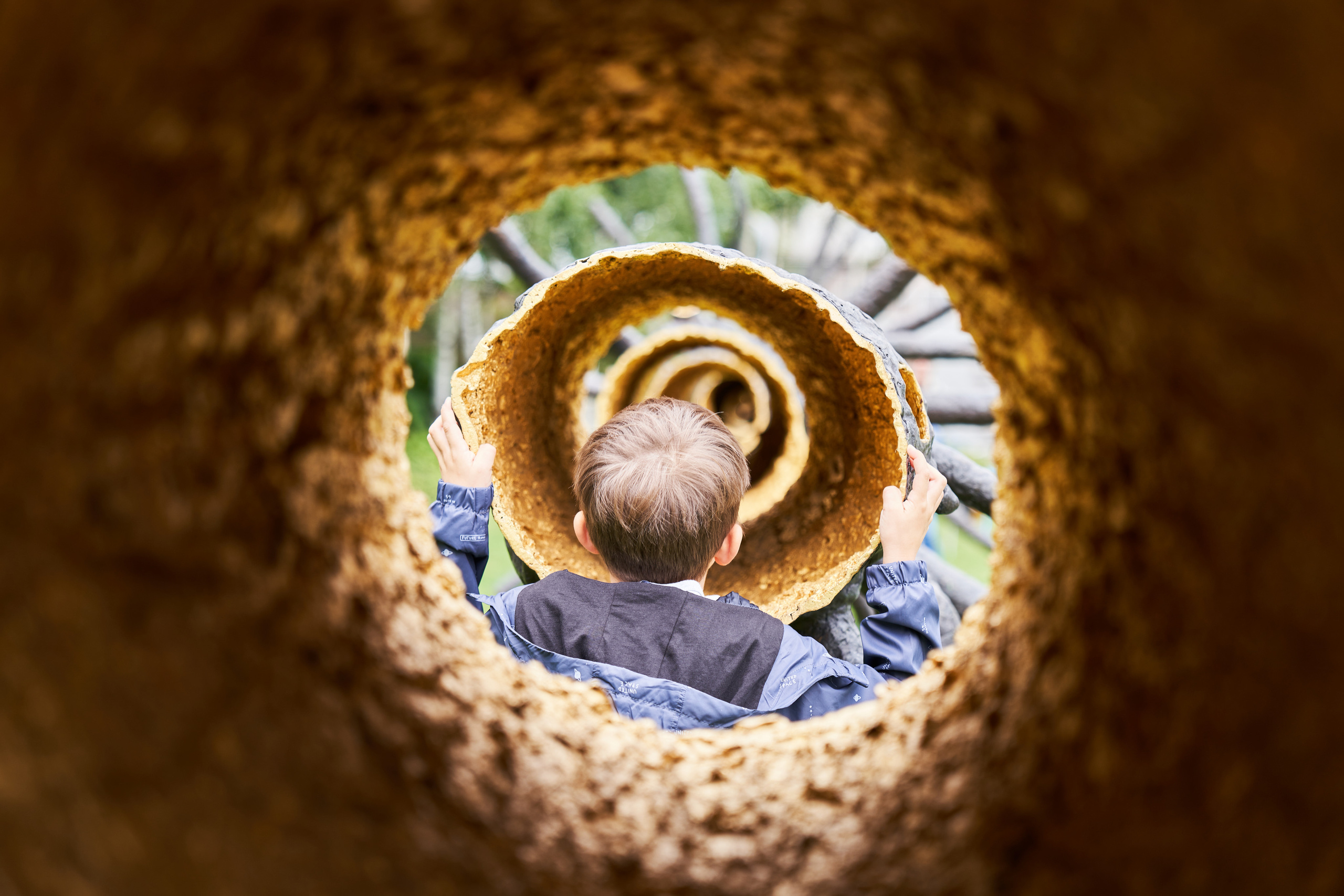 Ребенок смотрит в полое дерево композиции в саду ГЭС-2